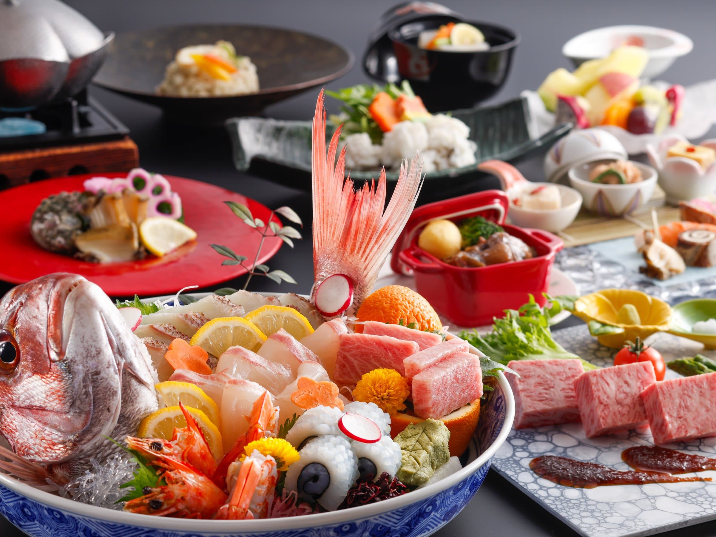 Multi-course kaiseki dinner spread with whole sea bream sashimi, wagyu beef and seasonal dishes at Dogo Onsen Hanayuzuki