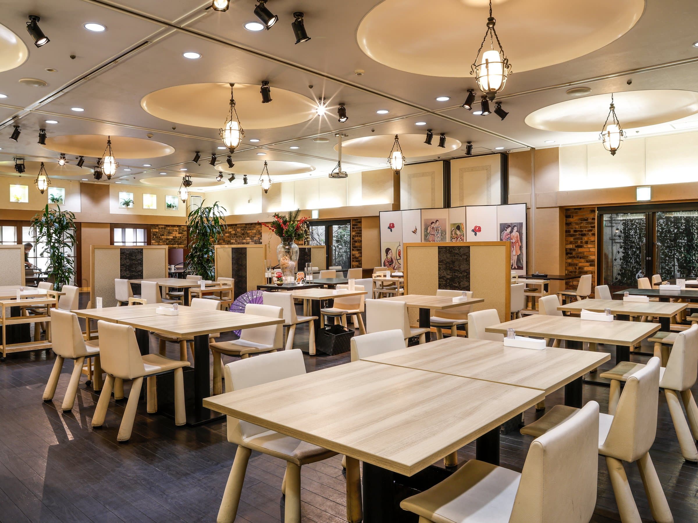 Bright dining hall with light wood tables, lantern lighting and circular ceiling features at Dogo Onsen Hanayuzuki