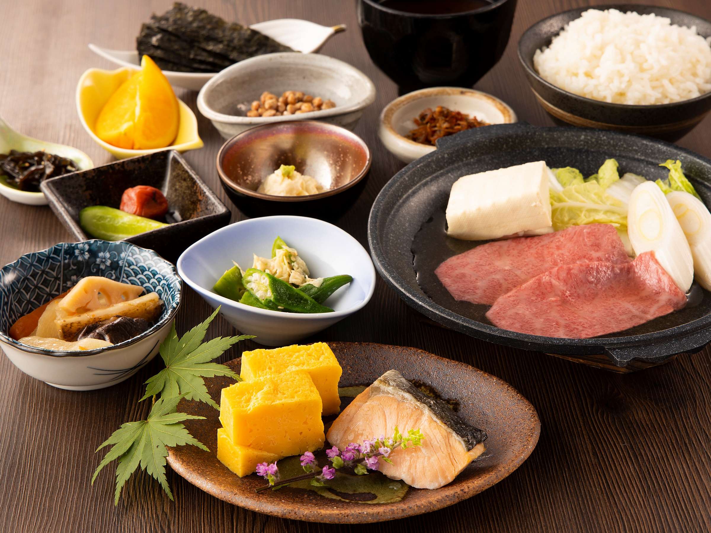 Japanese dinner set with grilled fish, beef sukiyaki pot, rice and assorted small side dishes