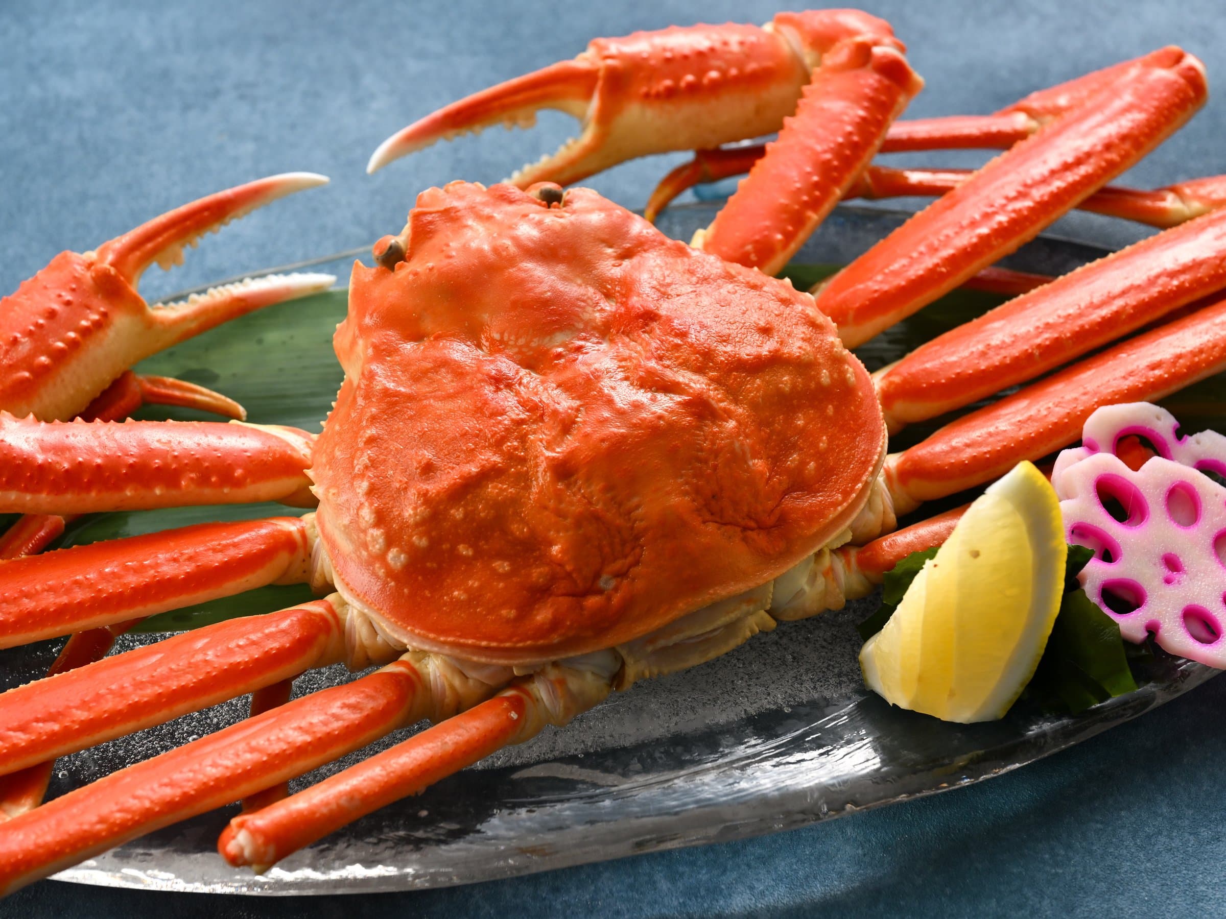 Whole boiled snow crab plated with lemon as a seasonal kaiseki dish at Hamazuru