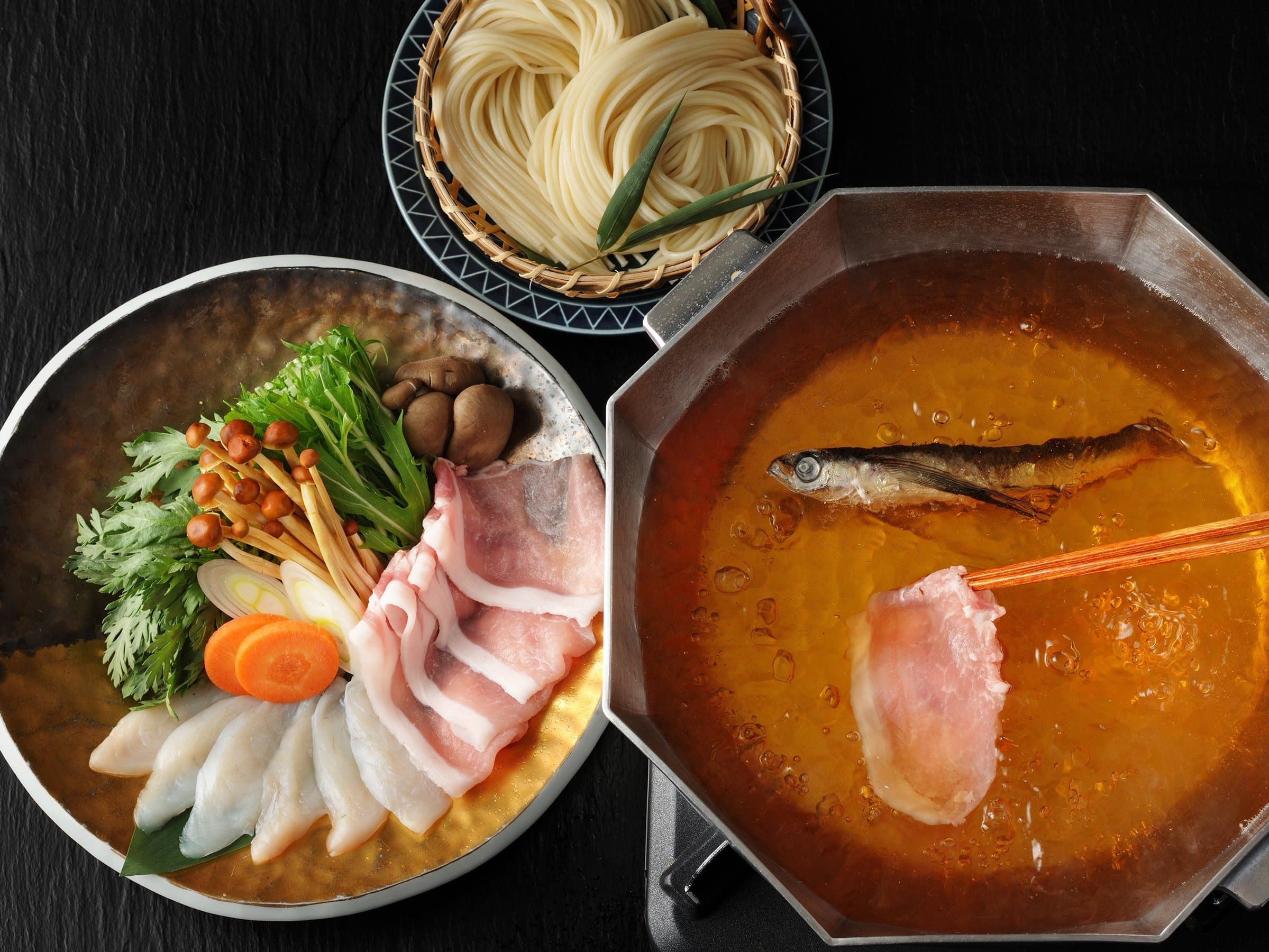 Local hot-pot dinner at KAI Unzen with sliced pork, fish, vegetables and noodles served in a simmering broth
