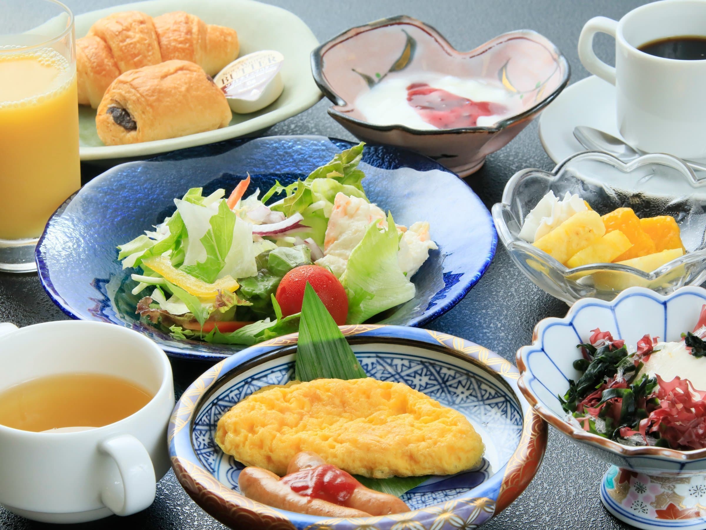 Light breakfast set at Yuyado Miyuki Honkan with omelette and sausage, croissants, salad, yogurt, juice and coffee
