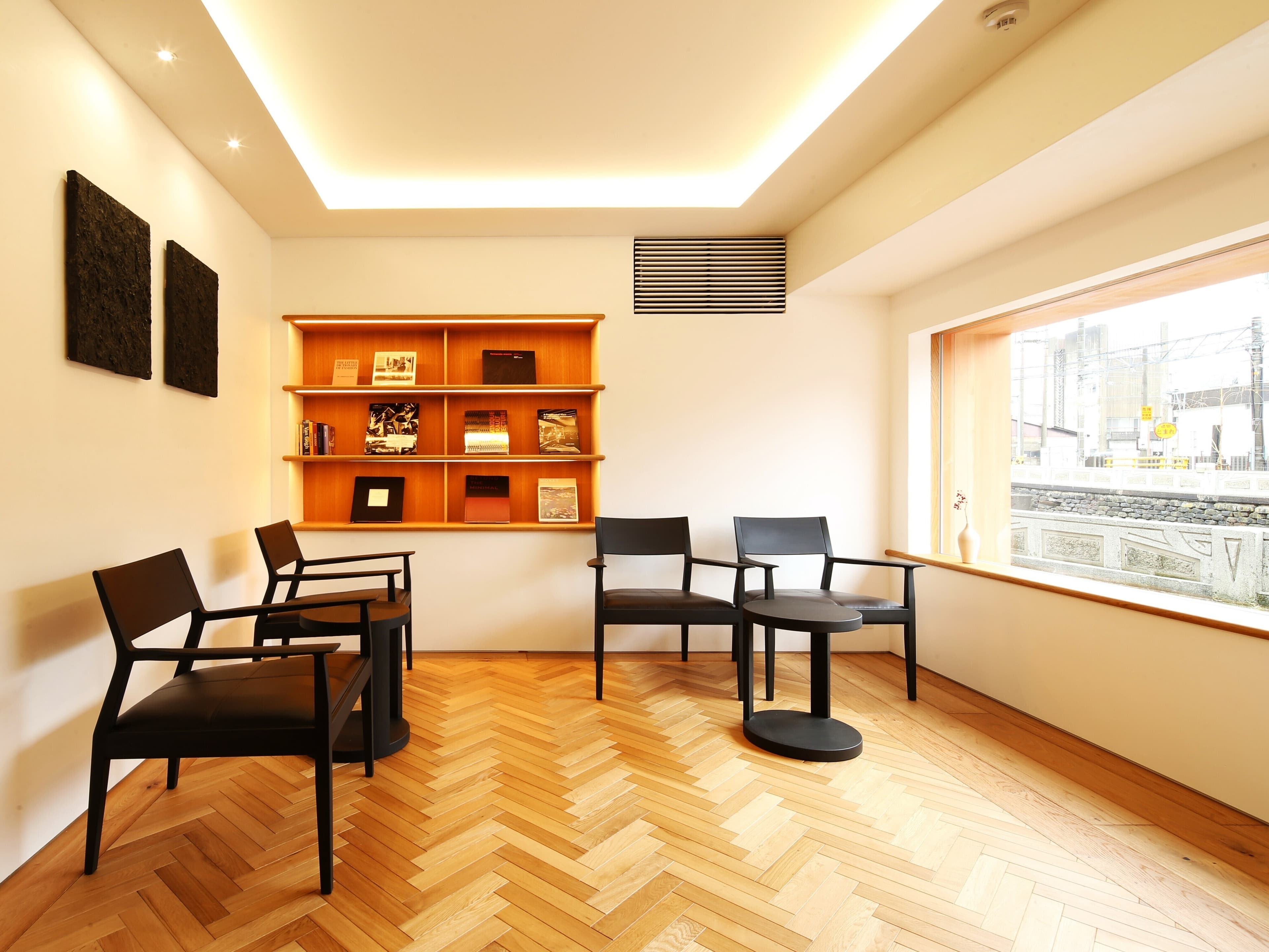 Lounge at Ichidaya with wood-paneled walls and street-facing windows