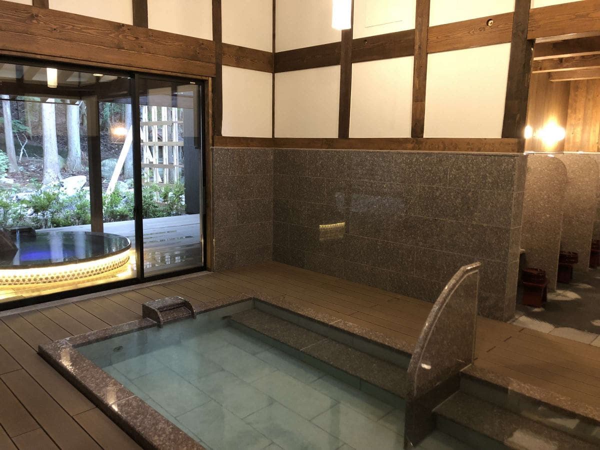 Reconstructed folk-house kominka communal bath amid lush gardens