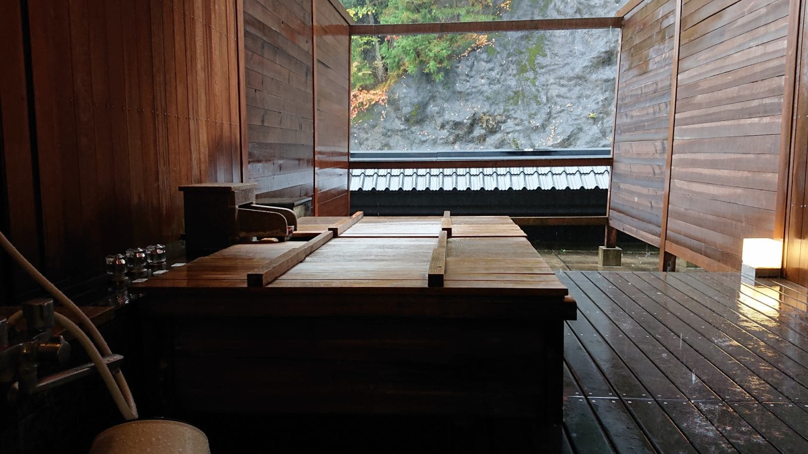 Garden open-air bath with natural rock formation and trees