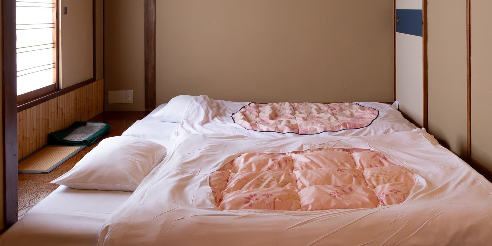 Futon bedding laid out on tatami flooring in a Japanese guest room at Hotel Edoya, Tokyo