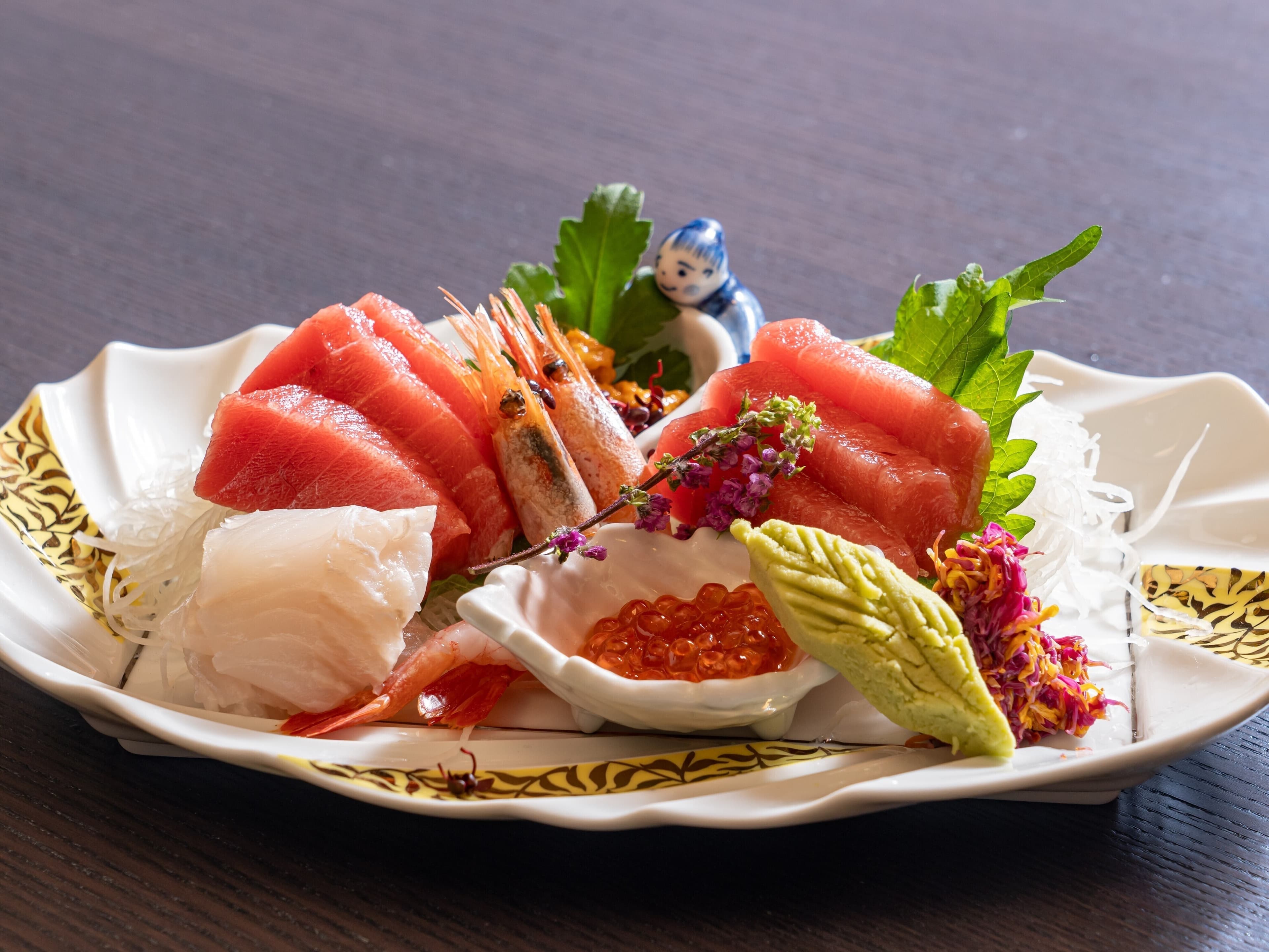 Fresh sashimi platter at Soraichi with tuna, prawn, ikura and wasabi on a decorative plate