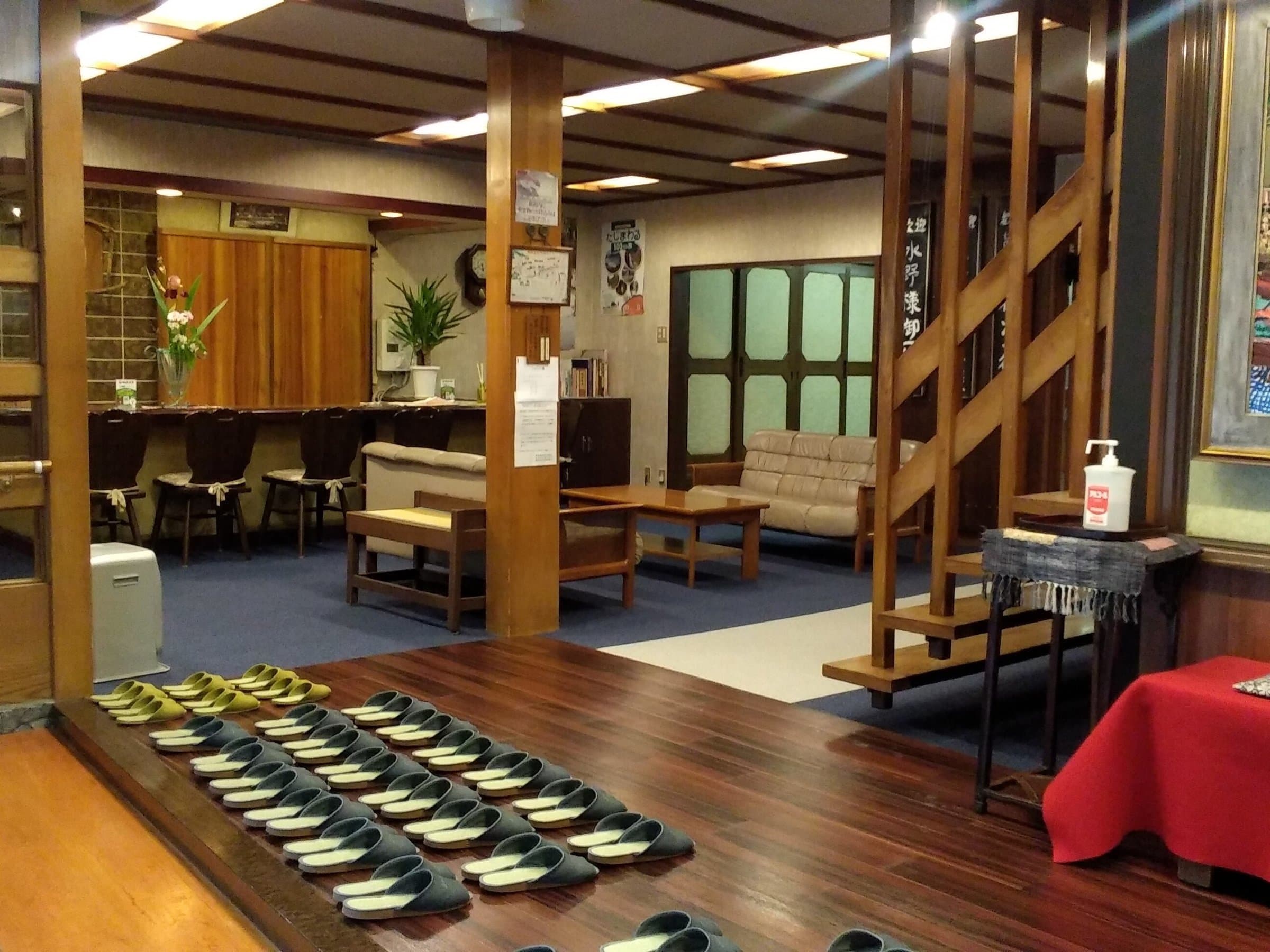 Matsuya lobby and entrance with rows of slippers, sofas and wooden staircase