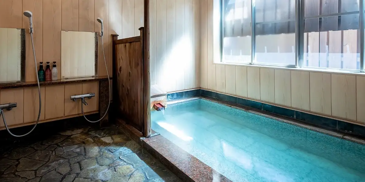Ichi-no-yu private reservable bath at Suehiroya Ryokan with a stone-floored washing area and a tiled hot spring tub by the window