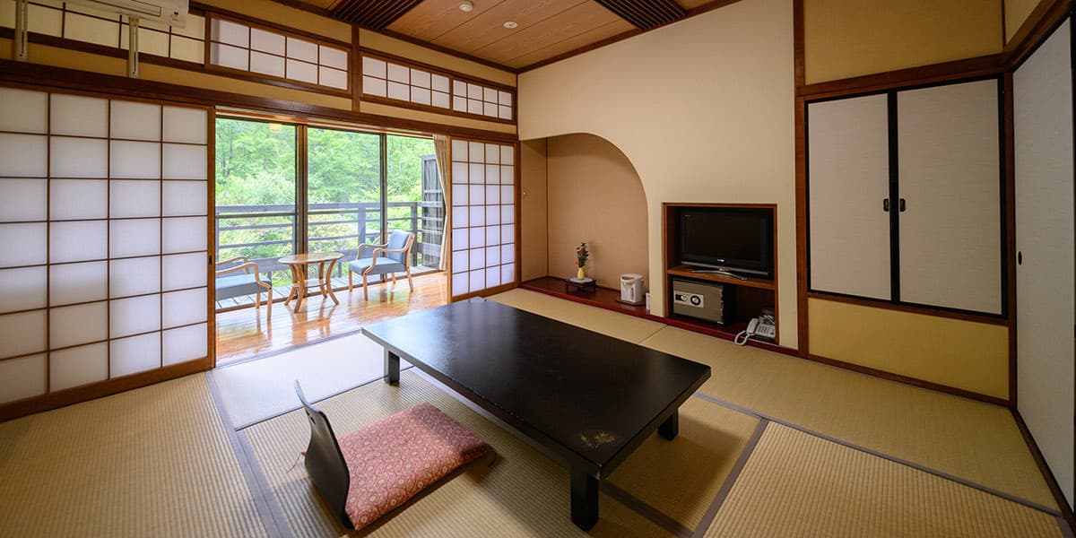 Yumerindo Hana-no-sha tatami guest room with low table, wide veranda and greenery outlook