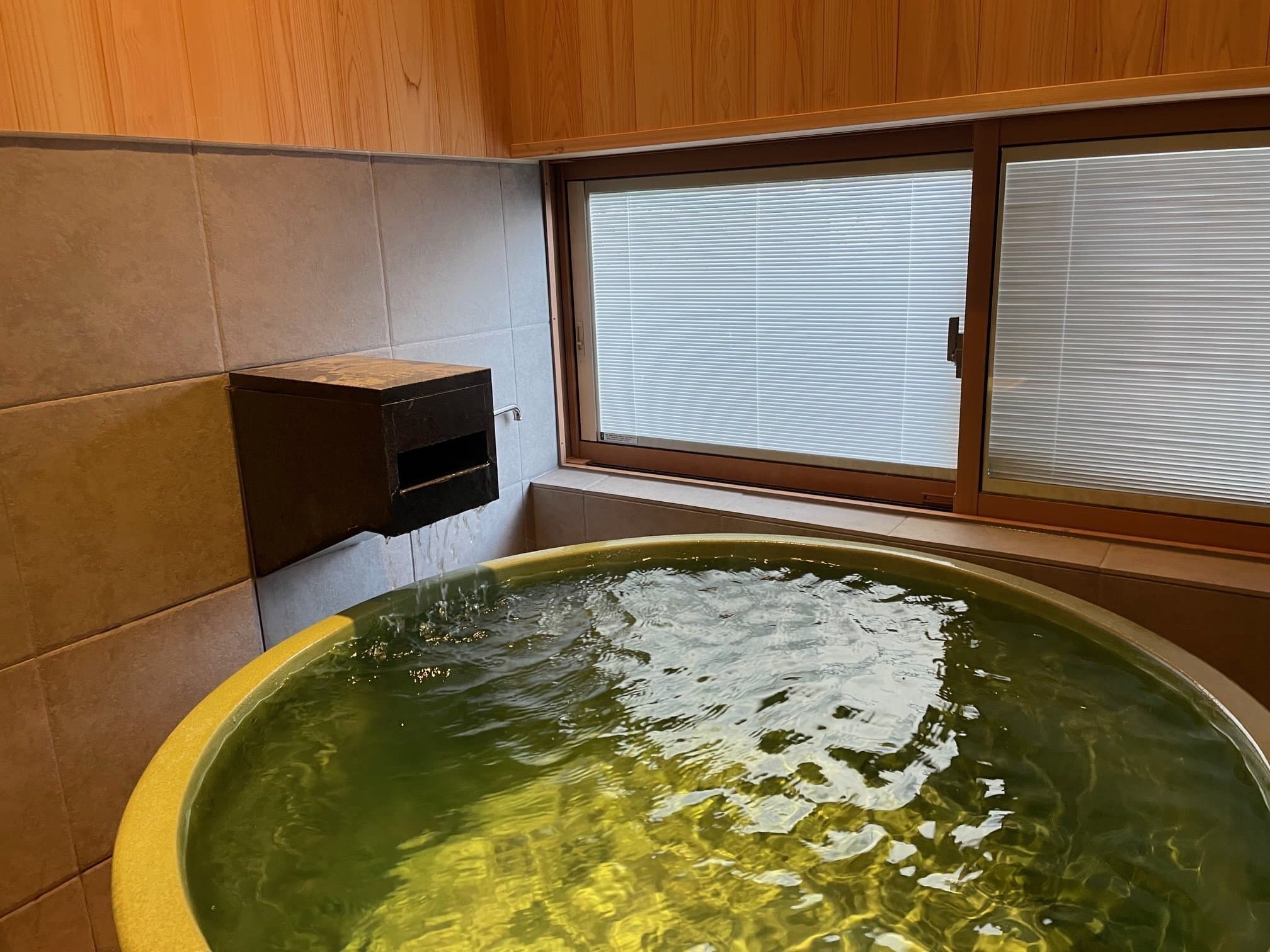 Round ceramic private hot-spring tub filled with free-flowing Kusatsu onsen water at Kusatsu Onsen Hoshikawa