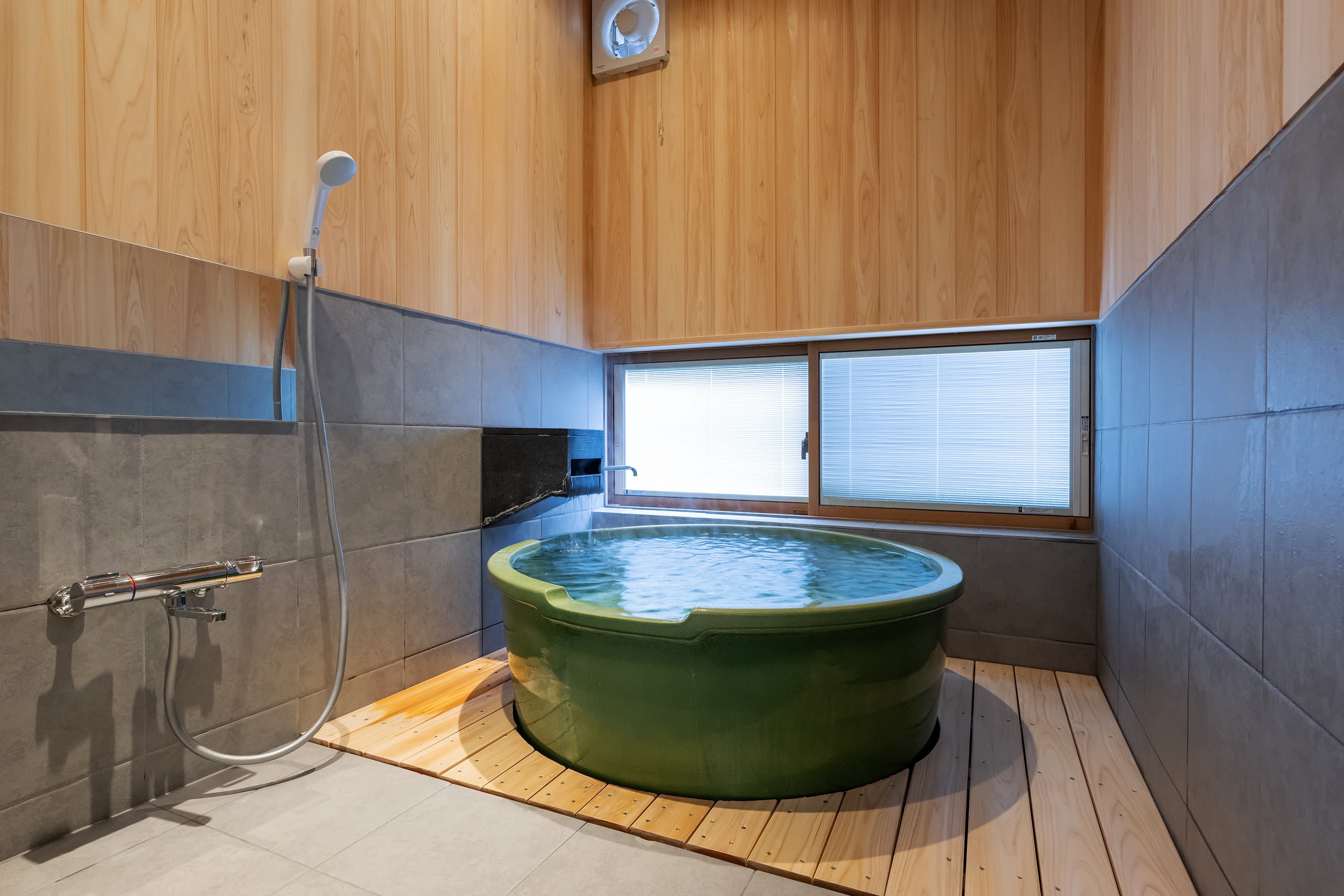 Private reservable bath at Kusatsu Onsen Hoshikawa with a round green ceramic tub of Bandai-mine spring water on a wooden deck