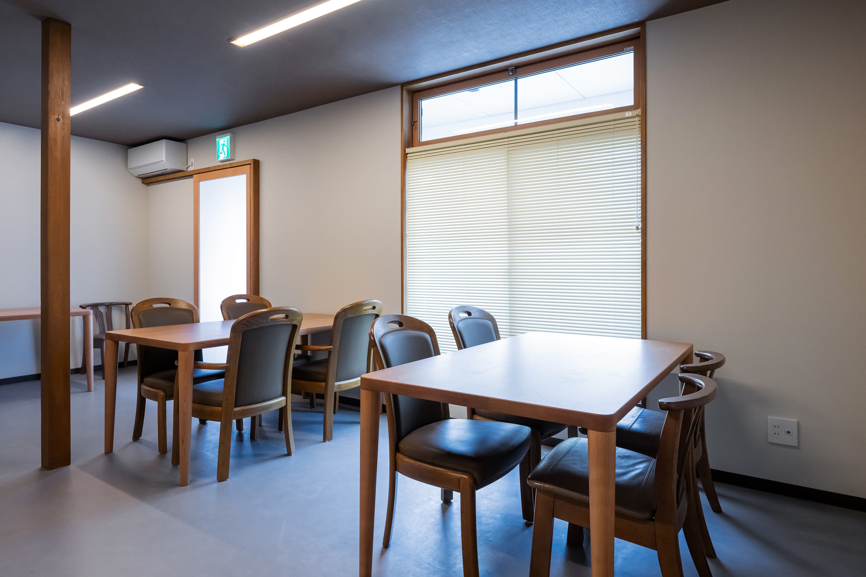 Bright dining room at Kusatsu Onsen Hoshikawa with wooden tables and chairs beside a large window