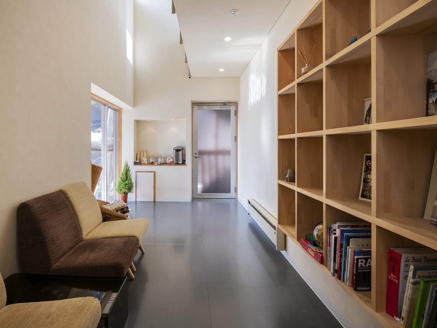 Bright Western-style guest room at Wata-no-Yu with twin beds, light wood floor and a raised tatami sitting area by the window