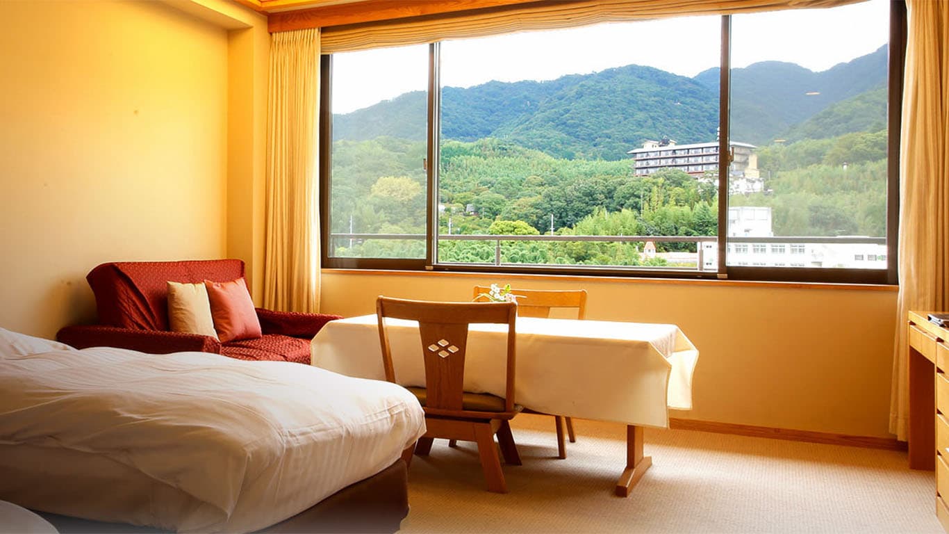 Western-style twin bedroom with a mountain view at Ginsuiso Choraku