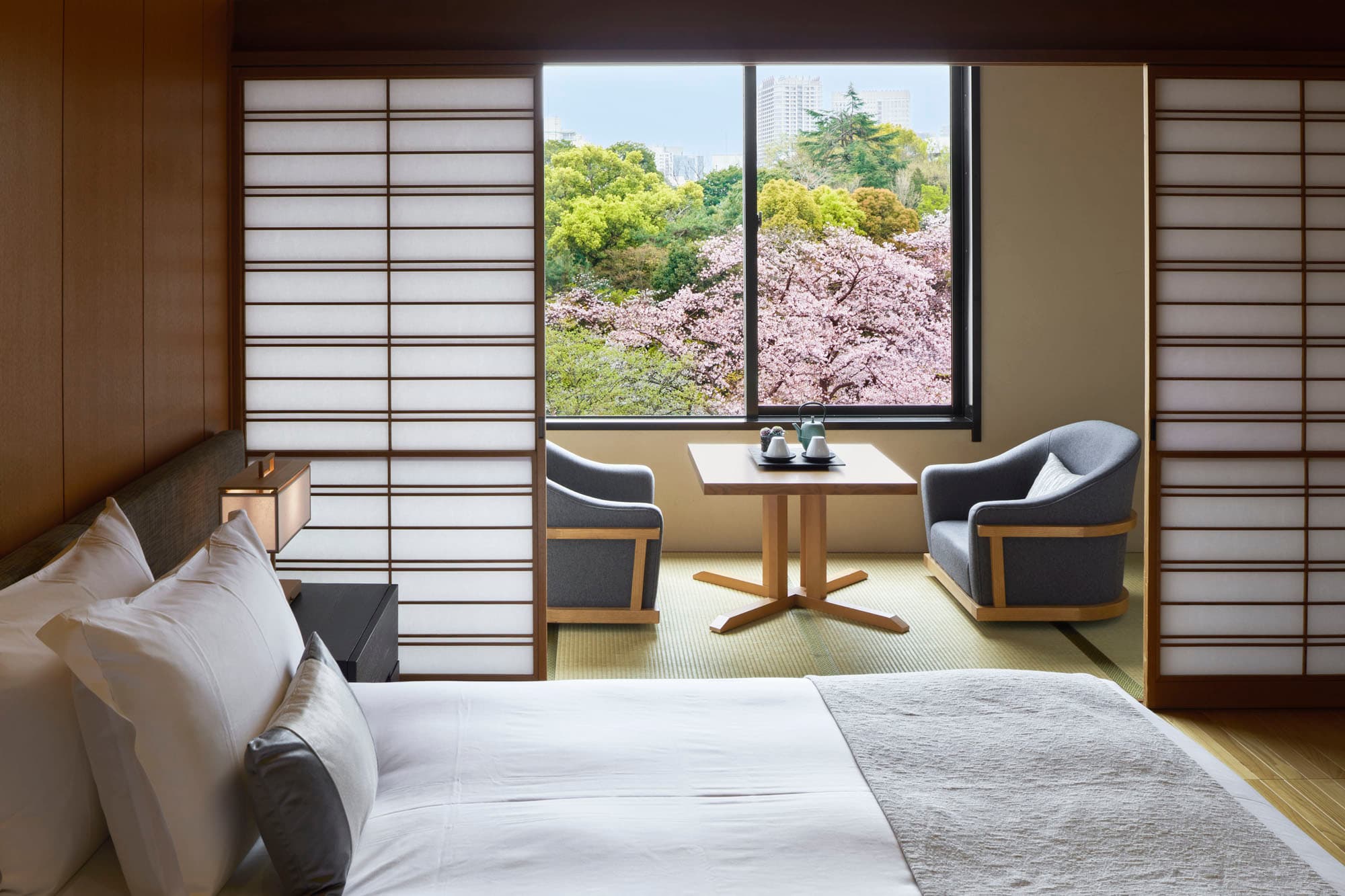 Premier Japanese Garden Suite with shoji screens and armchairs overlooking cherry blossoms at Takanawa Hanakohro Tokyo