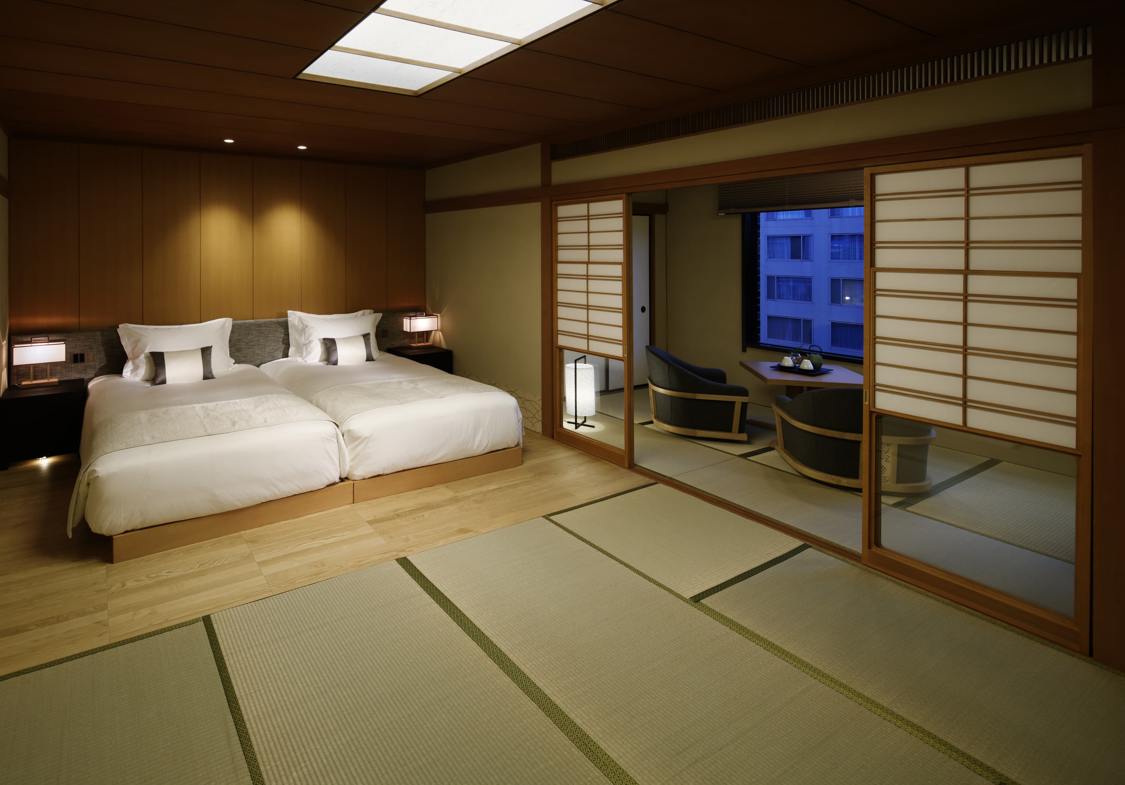 Japanese Garden Suite bedroom with twin beds, tatami and adjoining seating area at Takanawa Hanakohro in Tokyo