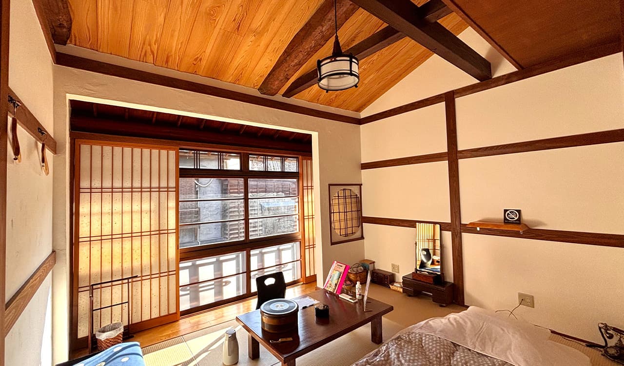 Bright tatami guest room with exposed beams, vaulted cedar ceiling and shoji-screened bay window at Tokiwaso, Dogo Onsen