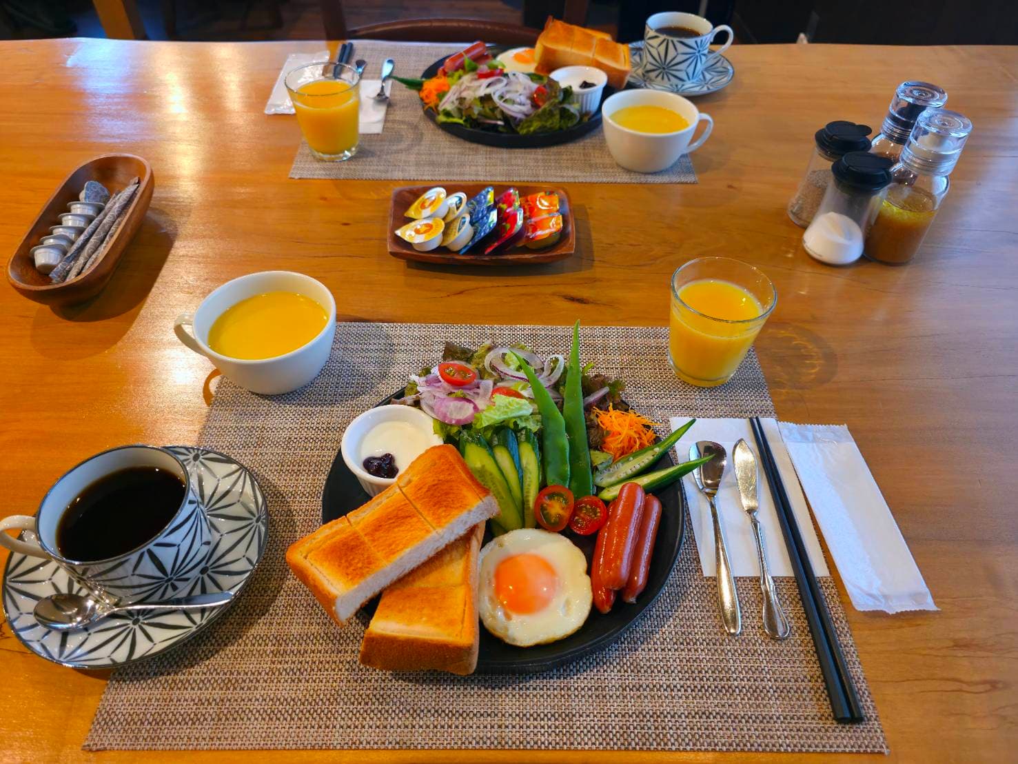 Western-style breakfast set with toast, fried egg, salad, soup, coffee and orange juice