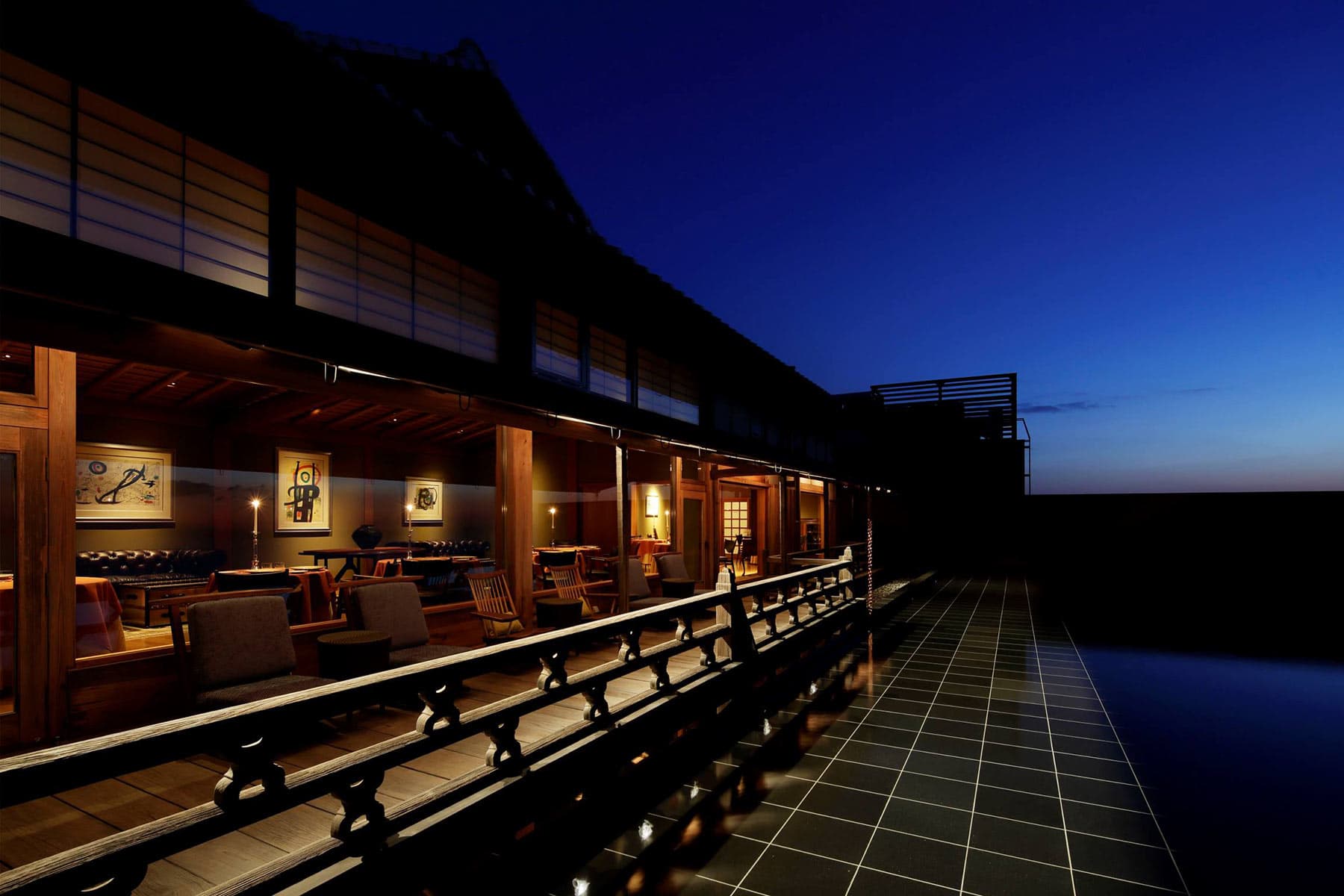 Veranda and open lounge of the Hiramatsu Atami at blue hour beside a tiled reflecting pool