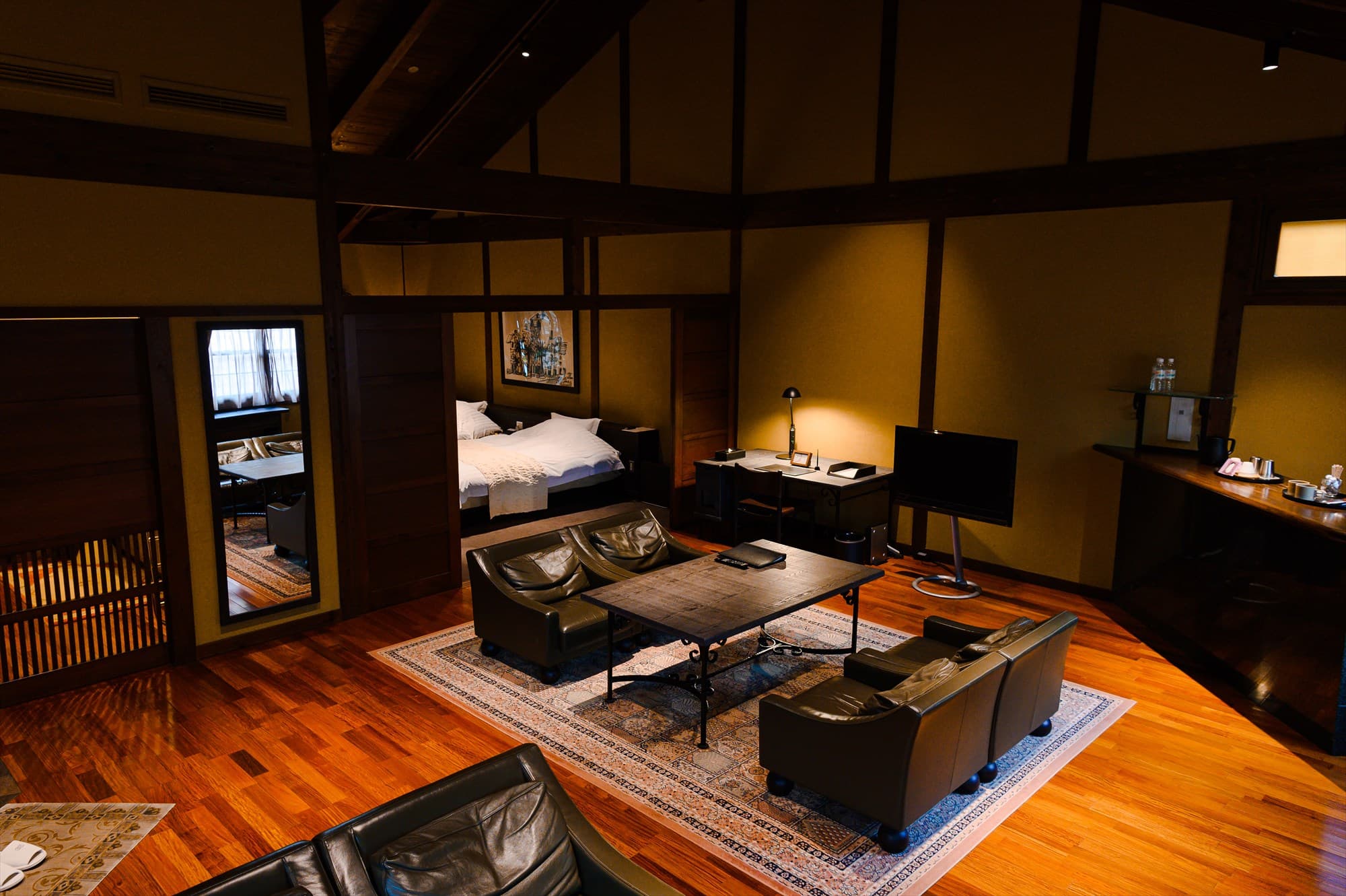 Private dining room with sunken irori hearth and dark wood architecture at Gosho Bessho