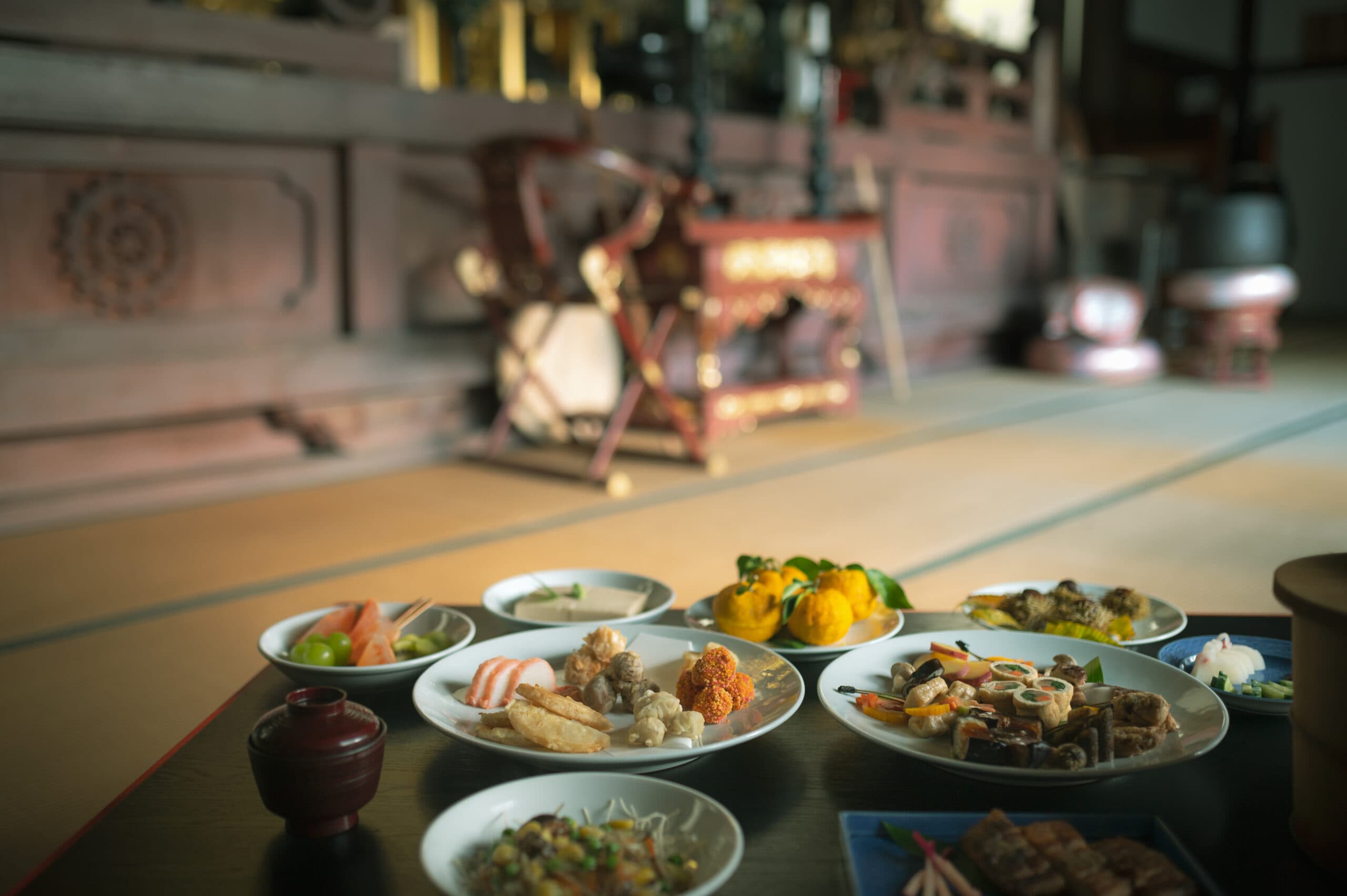 Multi-course kaiseki dinner arranged on a low table in a dimly lit private dining room at Gosho Bessho