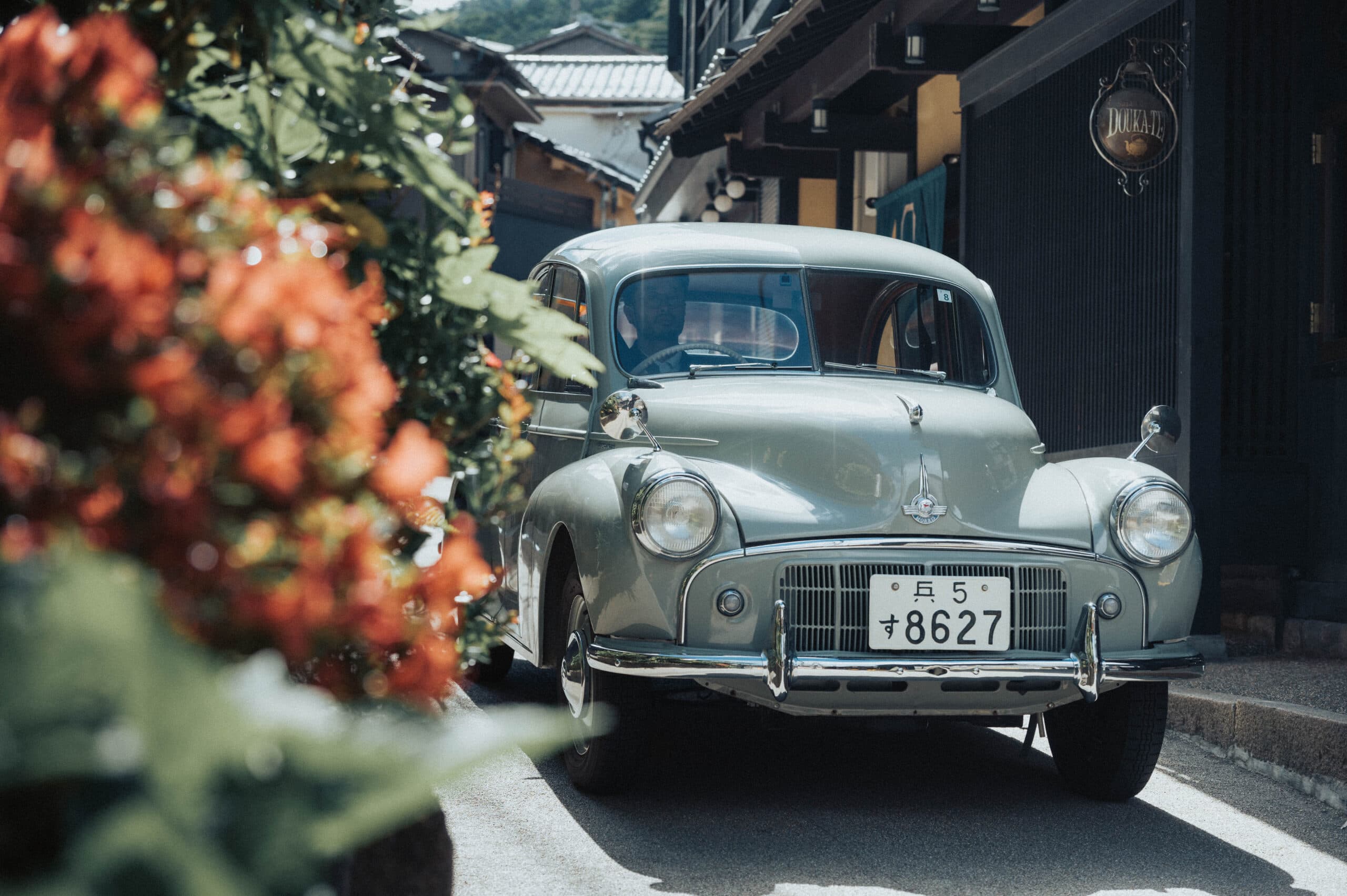 Arima Sanso Gosho Bessho signature vintage classic car parked before the dark timber villa facade amid autumn flowers