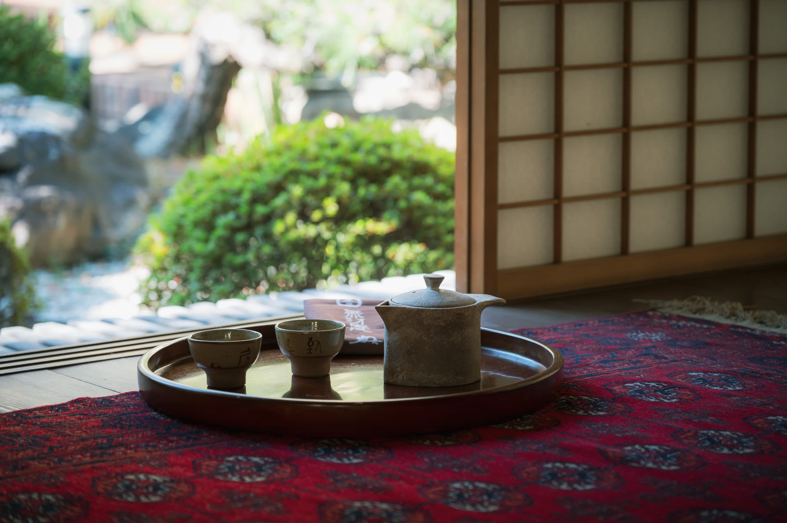 Welcome tea and sweets set on a tray in a tatami room with shoji screens at Gosho Bessho
