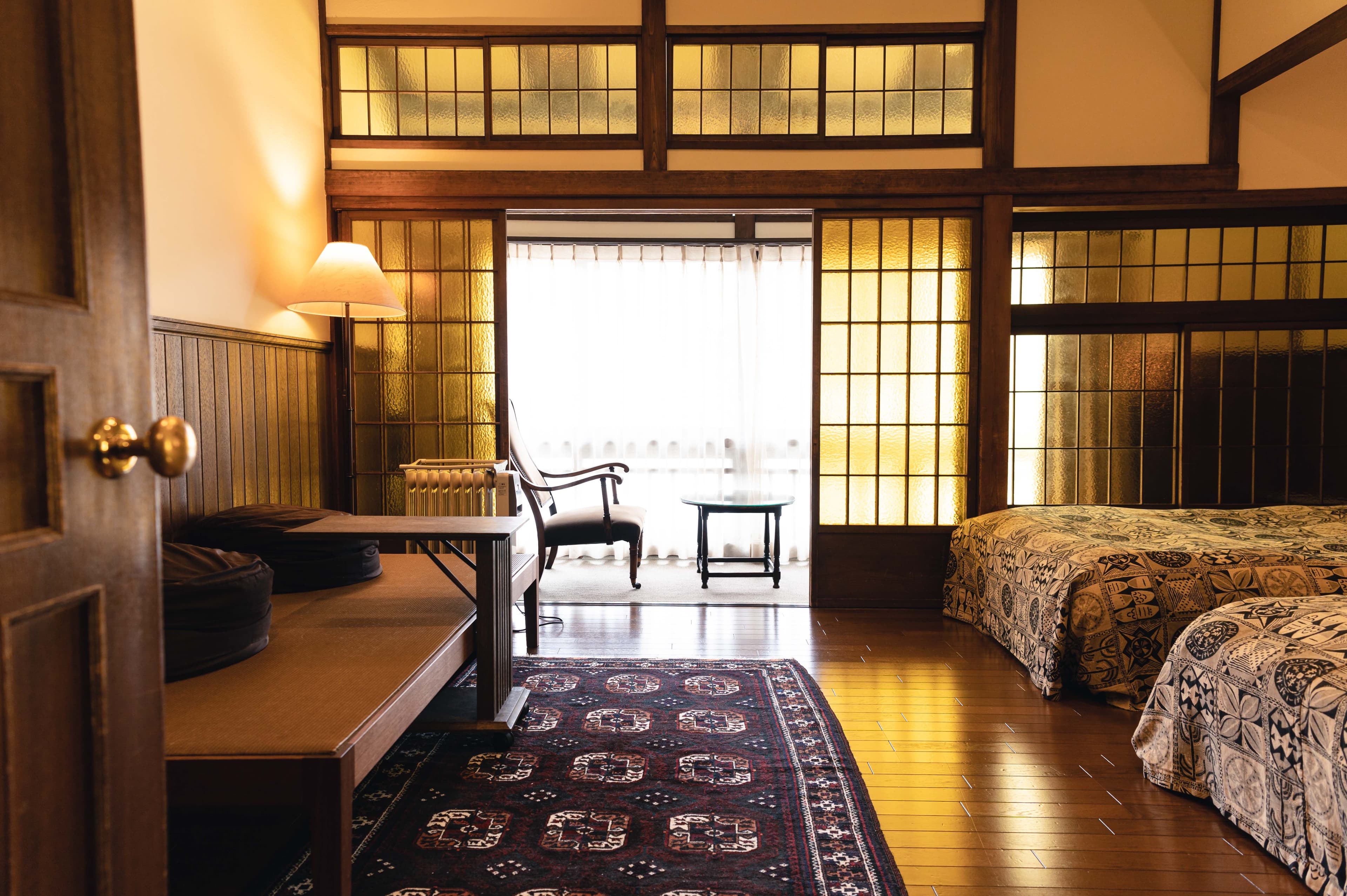 Western-style guest room with vintage furniture, Persian rug and stained-glass shoji at Hotel Hanakoyado, Arima Onsen