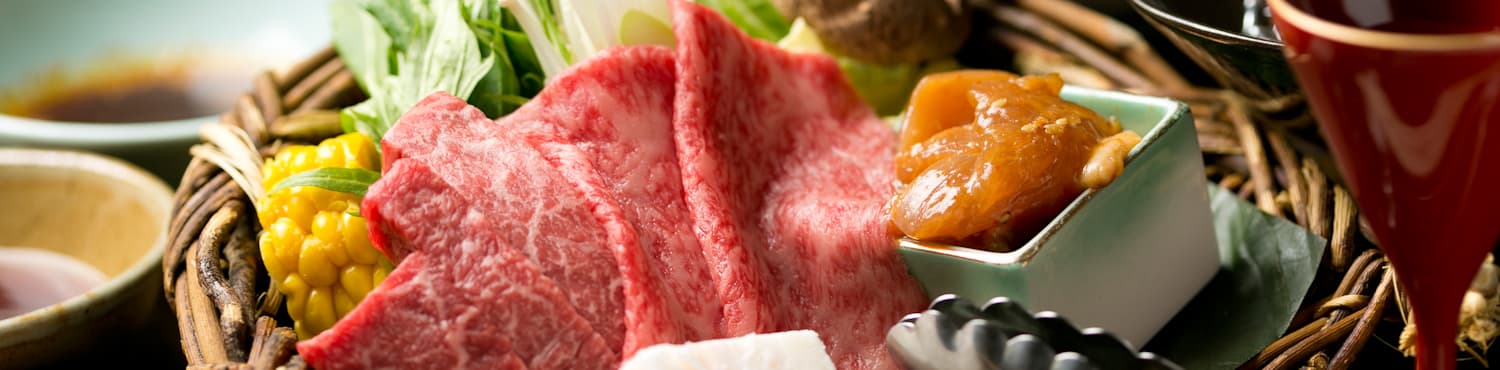 Marbled Hida wagyu beef plated with vegetables and dipping sauce for a dinner course at Hodakaso Yamano Iori in Takayama
