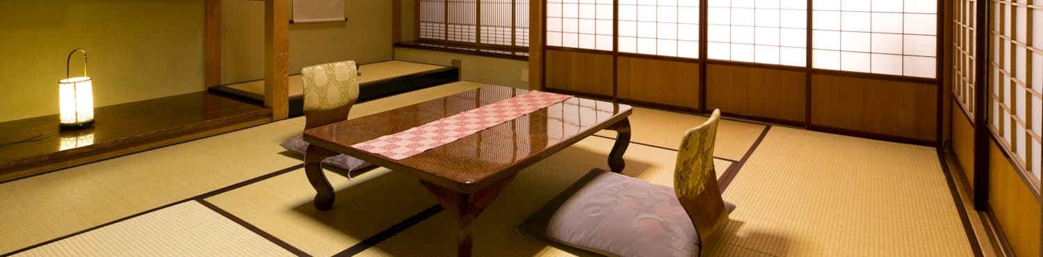 Spacious traditional tatami room with low lacquered table, floor cushions and shoji screens at Hida Takayama Hodakaso Yamano Iori