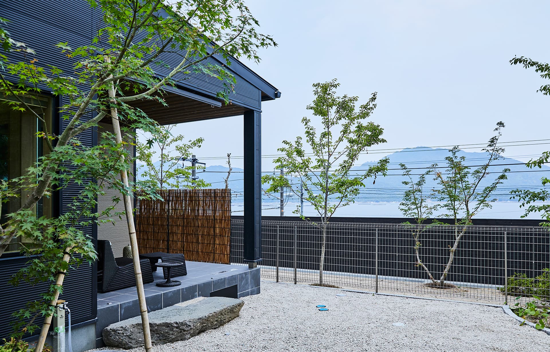 Detached villa at IBUKU with a private covered terrace and young maple garden looking out toward the sea