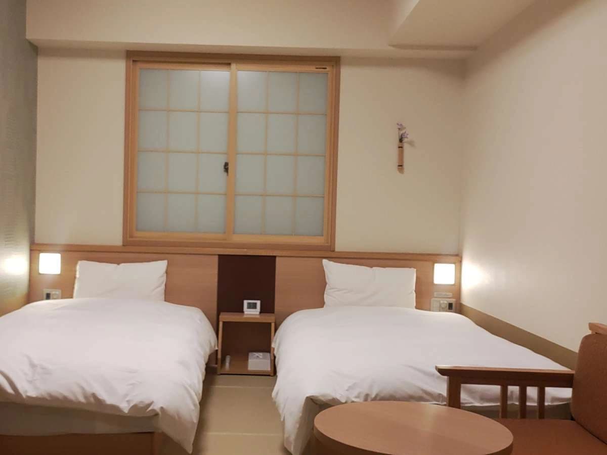 Bright single guest room at Onyado Nono Nara with large corner windows and tatami flooring