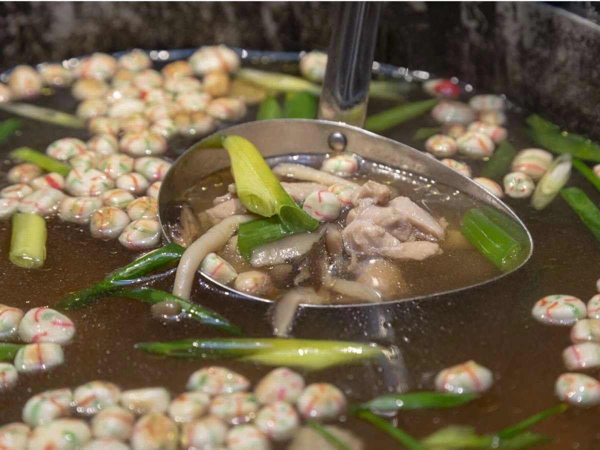 Simmering local hot pot served at Onyado Nono Nara, ladle lifting meat and vegetables
