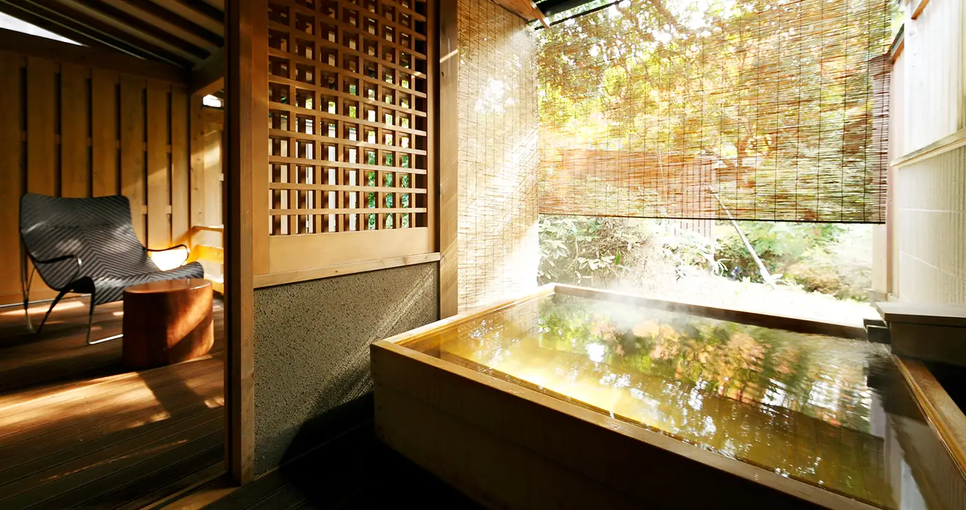 Private open-air wooden bath on a room terrace surrounded by foliage at Yu-Kairo Kikuya