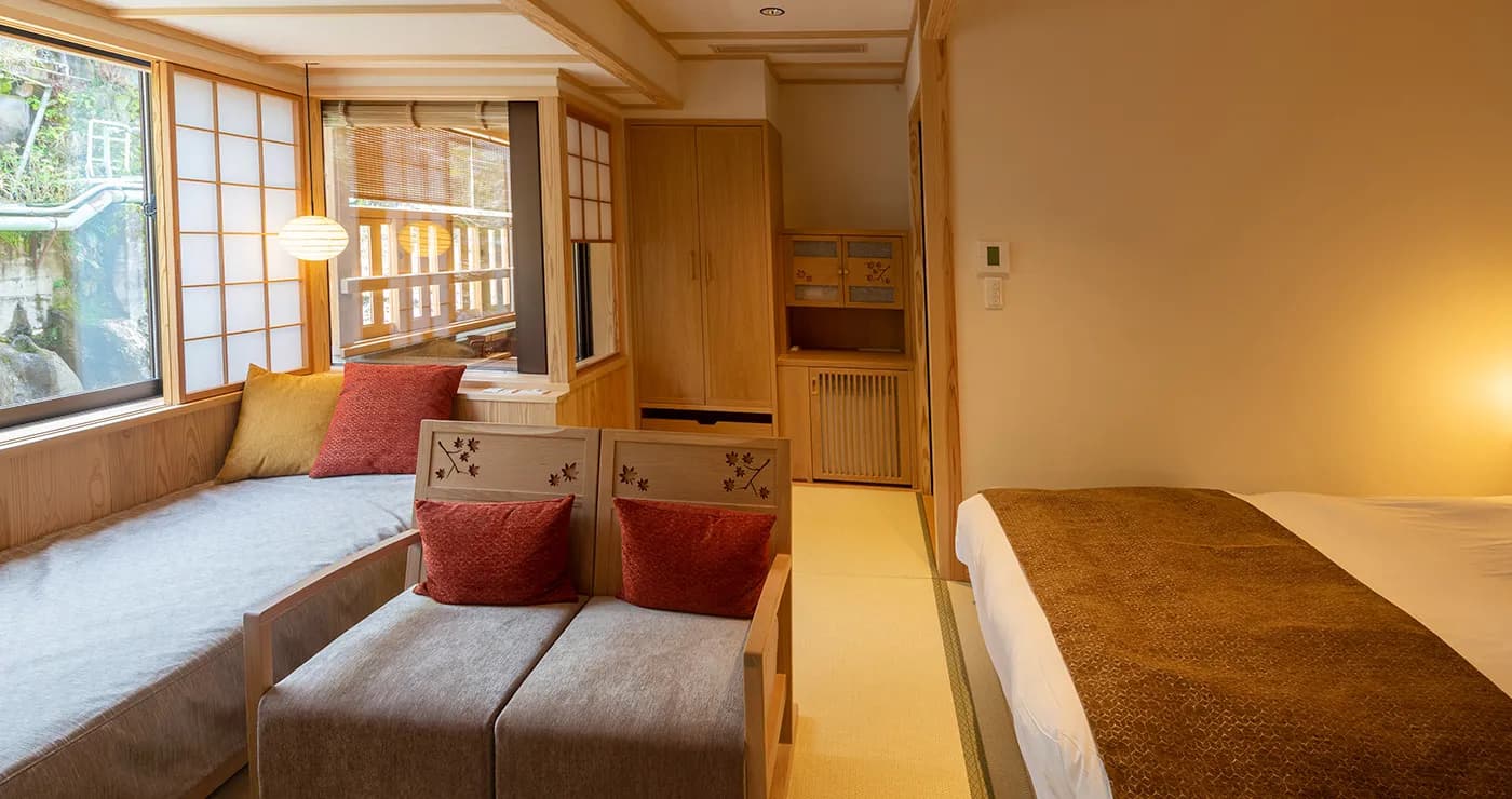 Spacious guest room with sofa lounge and private terrace overlooking greenery at Yu-Kairo Kikuya