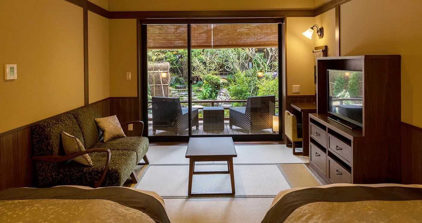 Guest room with seating area and garden-view balcony at Yu-Kairo Kikuya, Izu