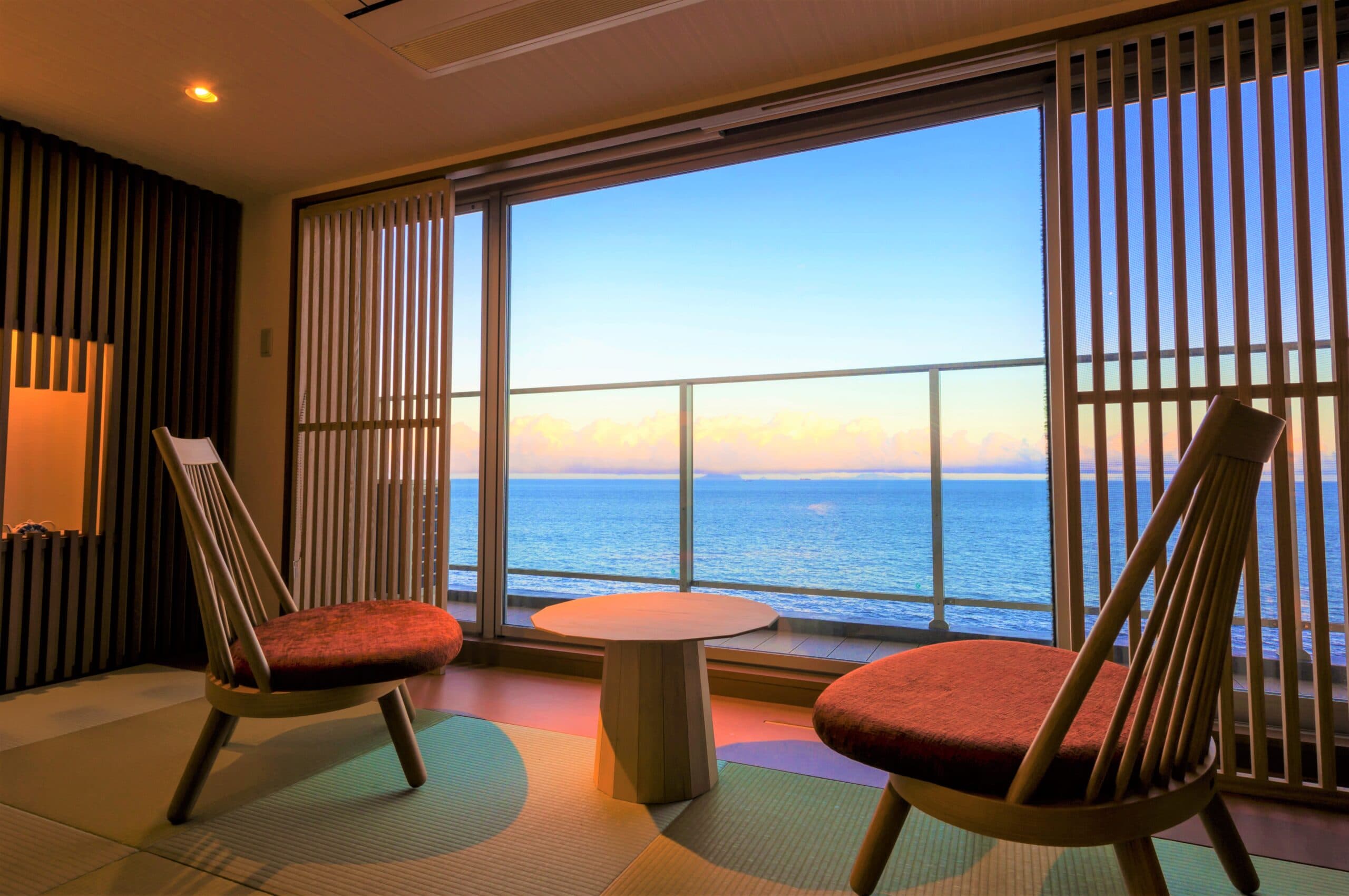 Tatami guest room at Inatoriso with low chairs facing a wide ocean-view window, Inatori Onsen, Izu