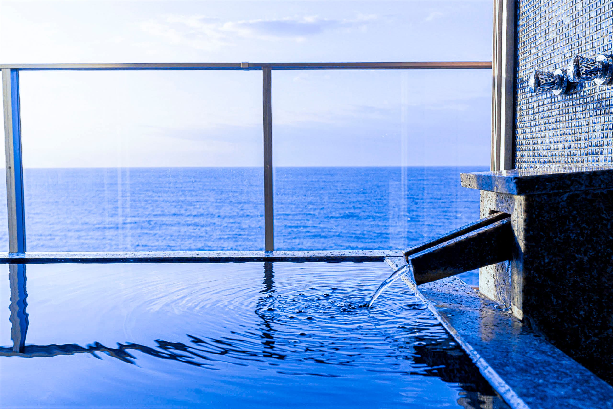 In-room open-air bath with a spout and sweeping sea view at Inatoriso, Inatori Onsen, Izu