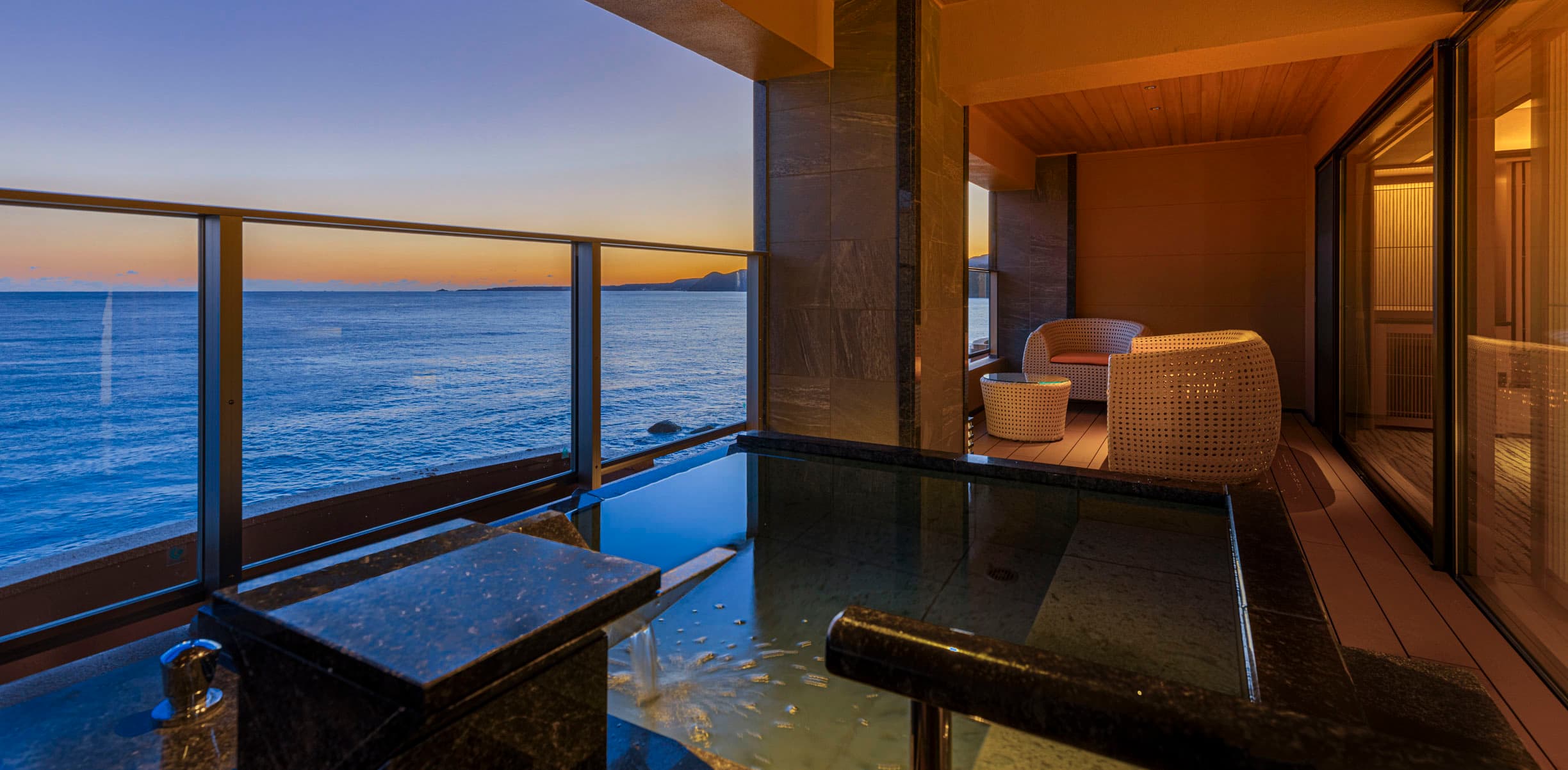 Private stone bath on a guest-room terrace at Inatoriso facing the ocean at sunset, Inatori Onsen, Izu