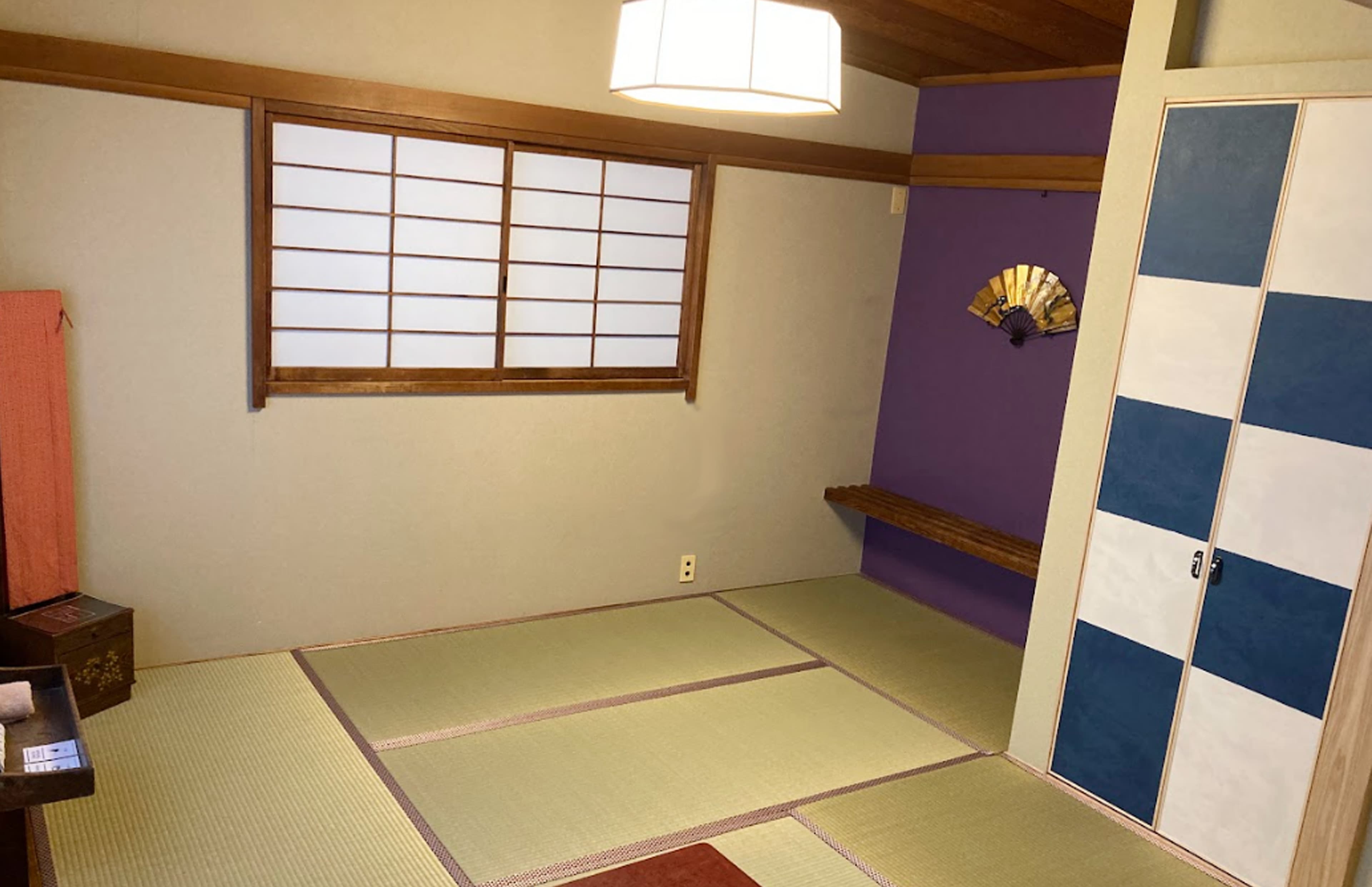 Tatami guest room at Ito Ryokan Tokyo with indigo checkered fusuma and low lacquer table