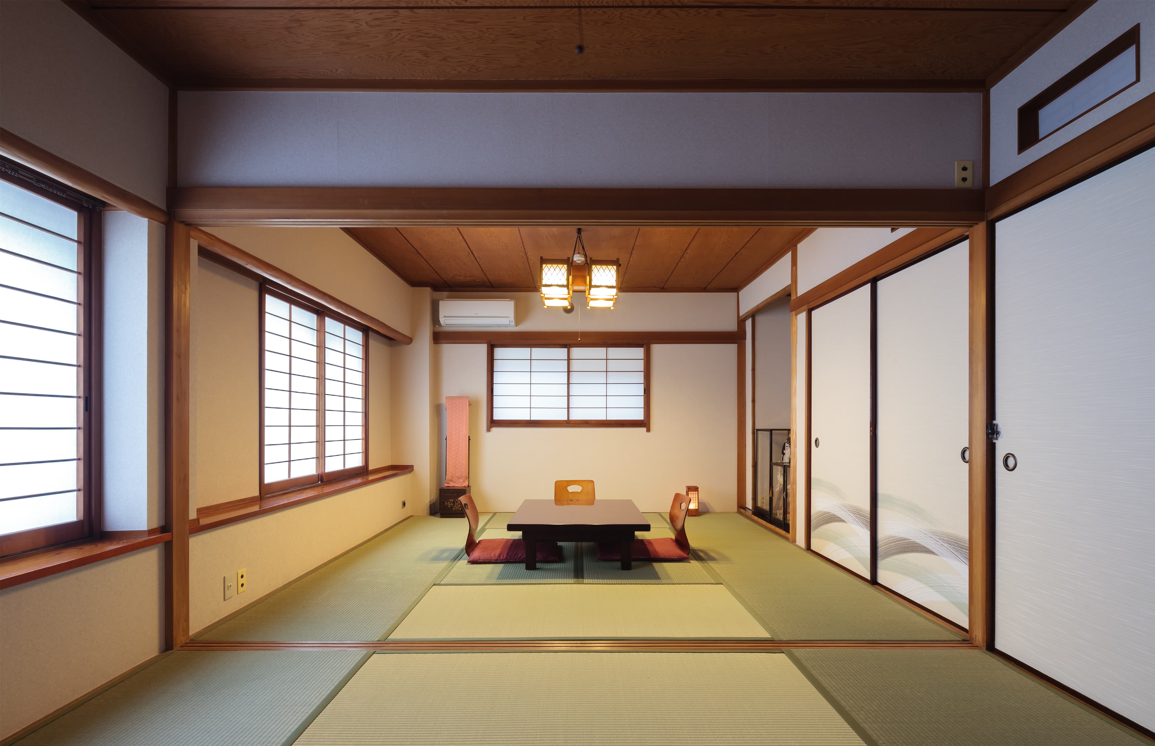 Large tatami guest room at Ito Ryokan Tokyo with low table, shoji windows and wood ceiling