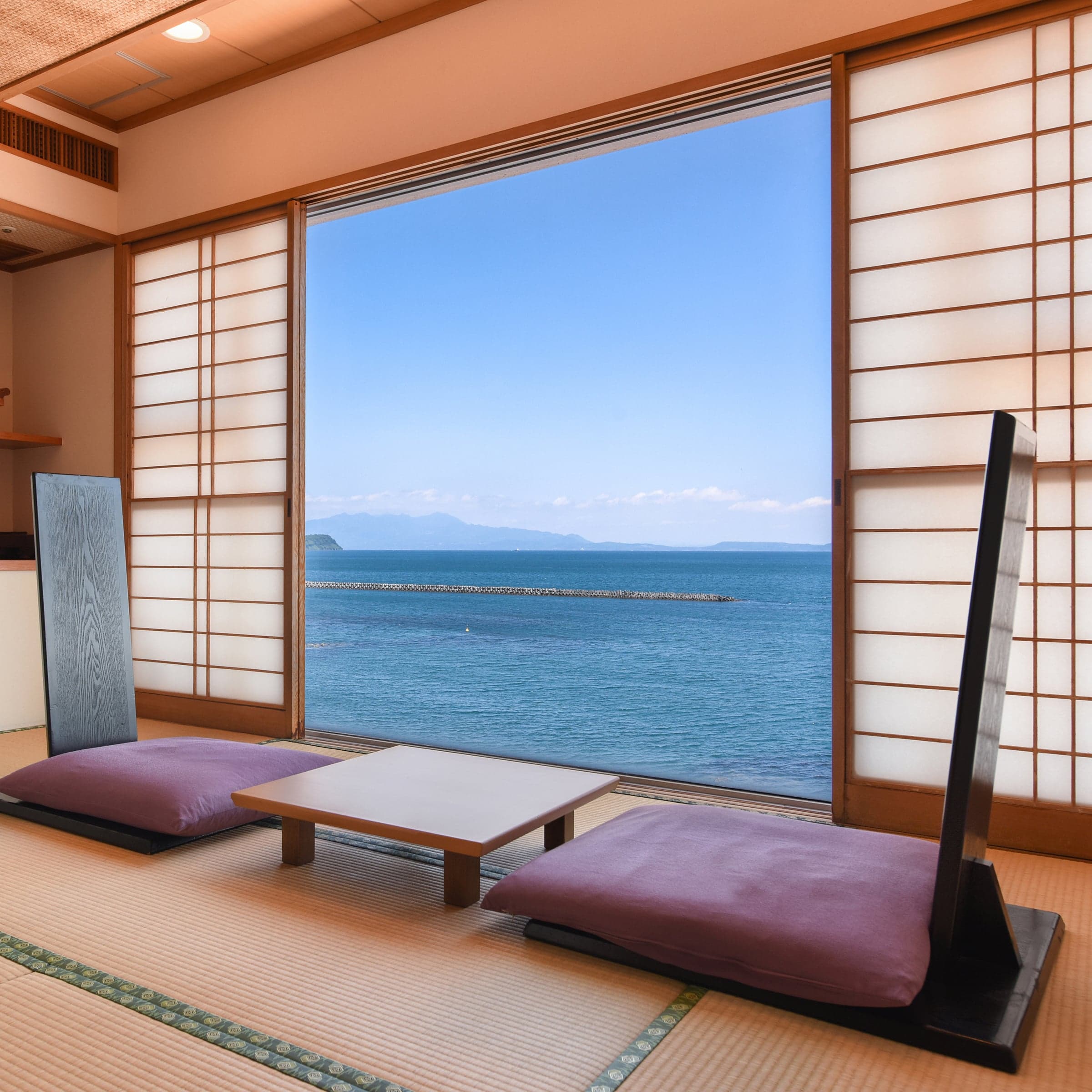 Traditional Japanese tatami room with shoji screens and a wide window framing the ocean at Ibusuki Kaijo Hotel