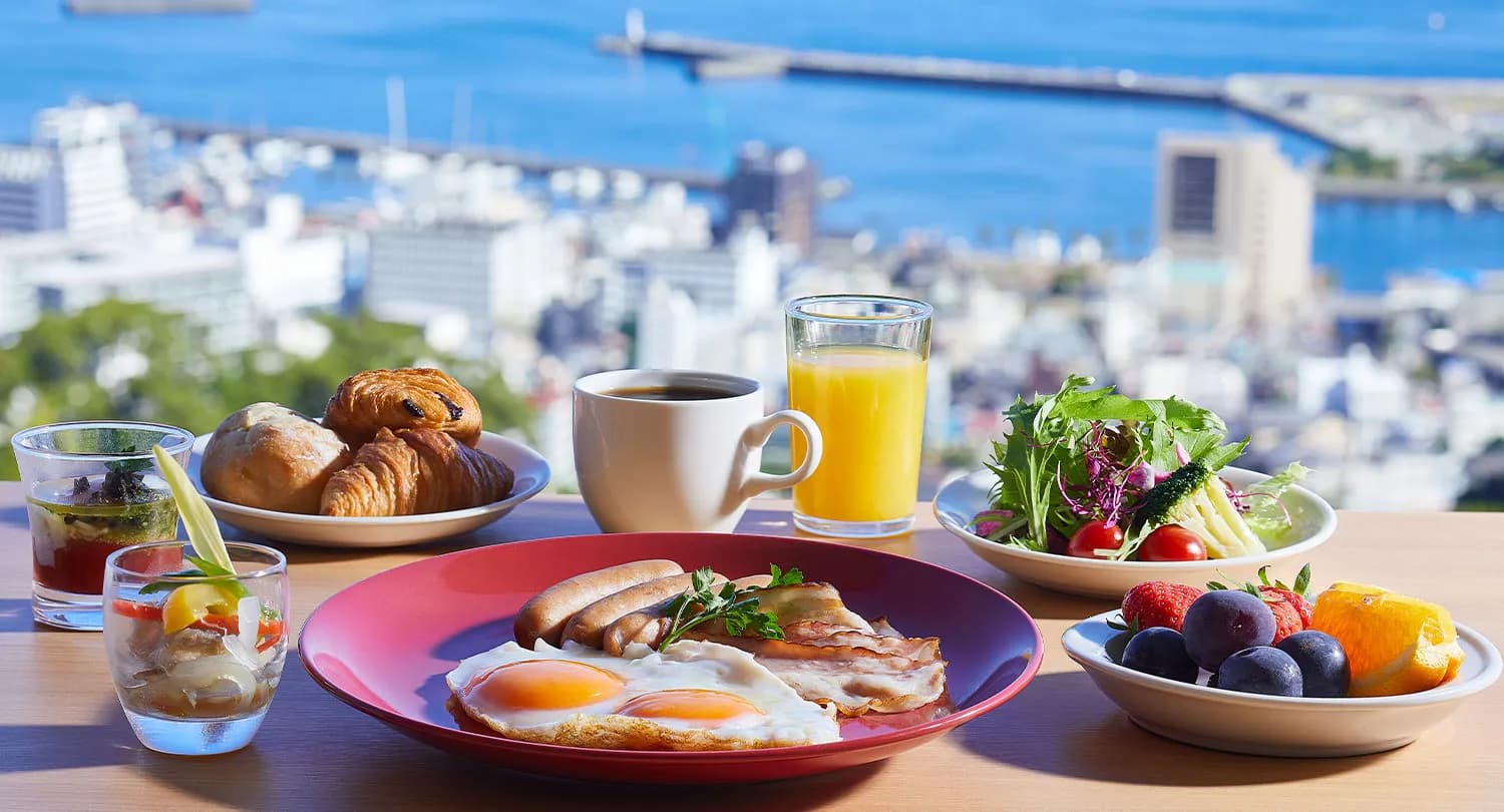 Breakfast set at Kamenoi Hotel Atami with eggs, salad, pastries and coffee overlooking Atami bay