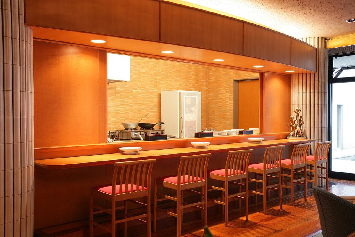 Counter dining area with an open kitchen and wooden bar seats