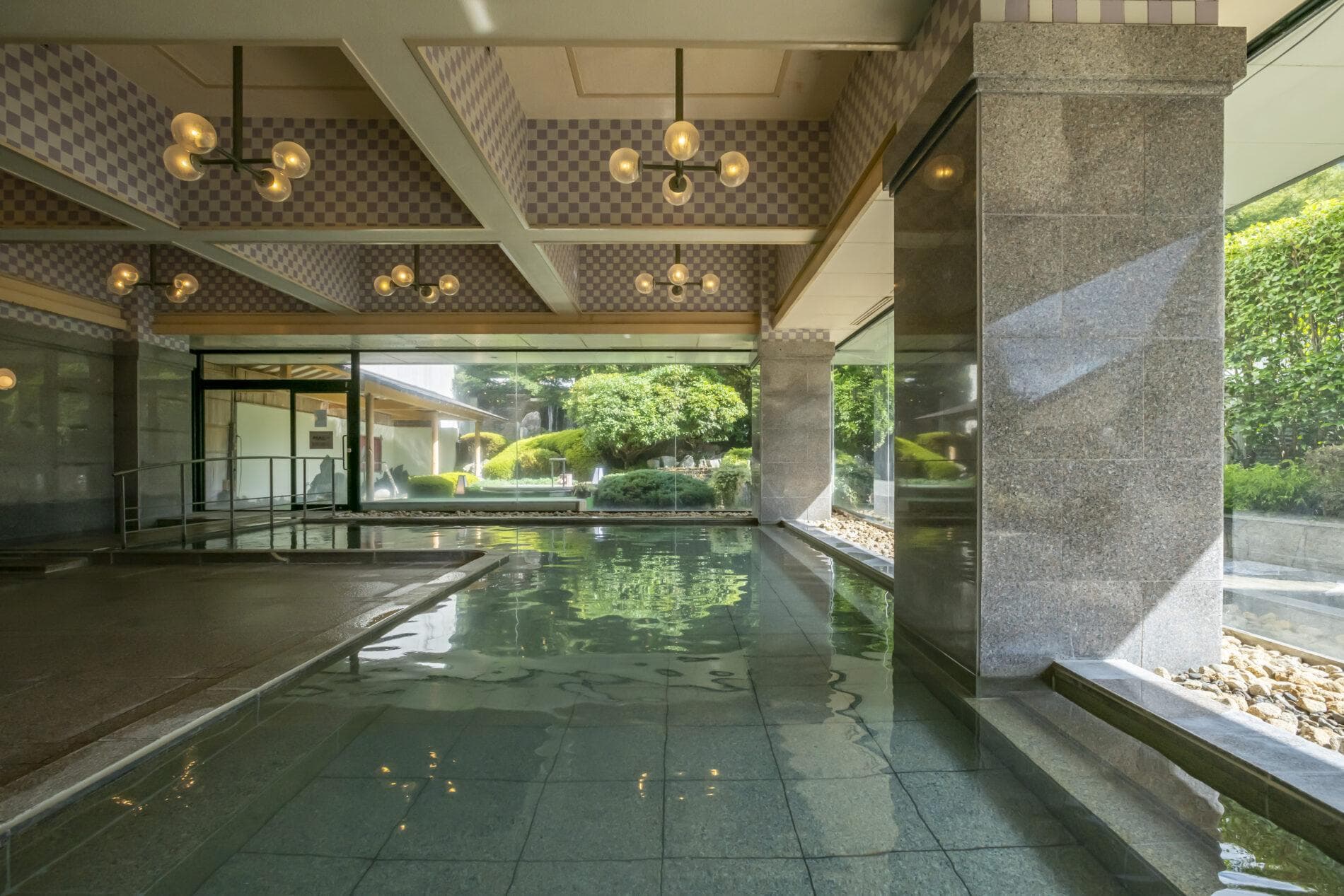 Indoor hot spring bath with garden view and glass walls at Kinugawa Grand Hotel Yume no Toki