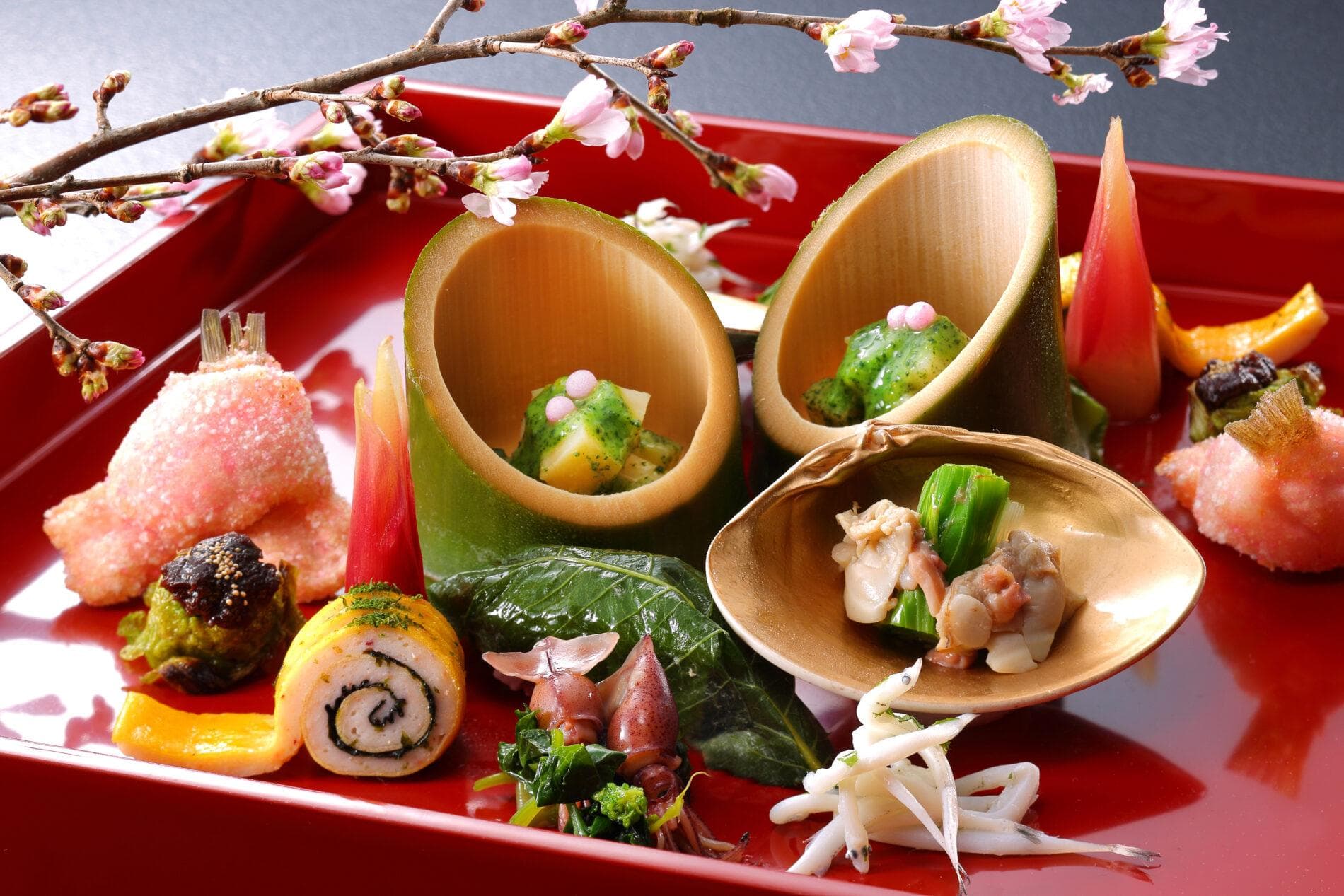 Kaiseki appetizer course plated on red lacquer with seasonal cherry blossom garnish at Yume no Toki