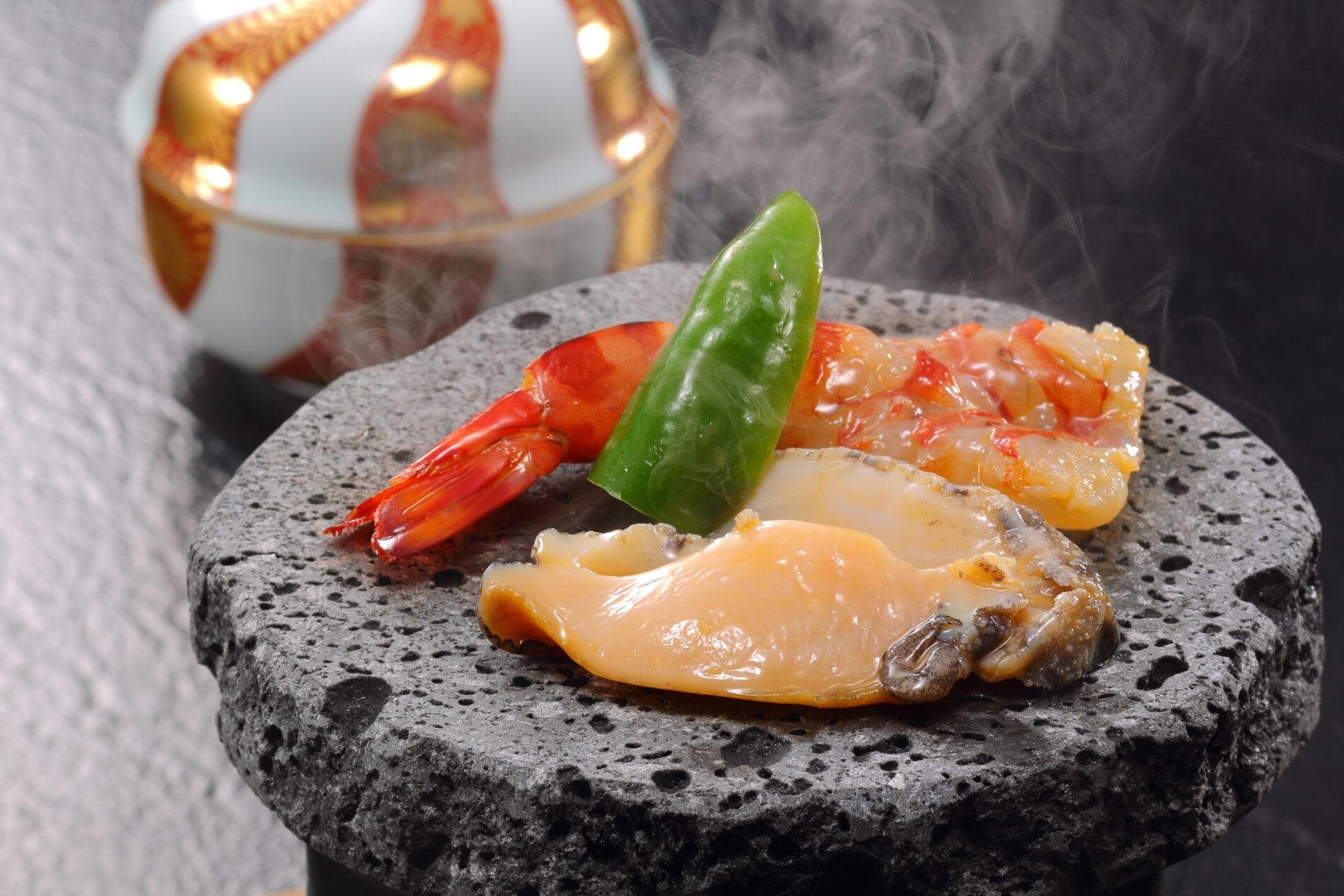 Steaming stone-grilled prawn and shellfish course served on lava stone at Yume no Toki