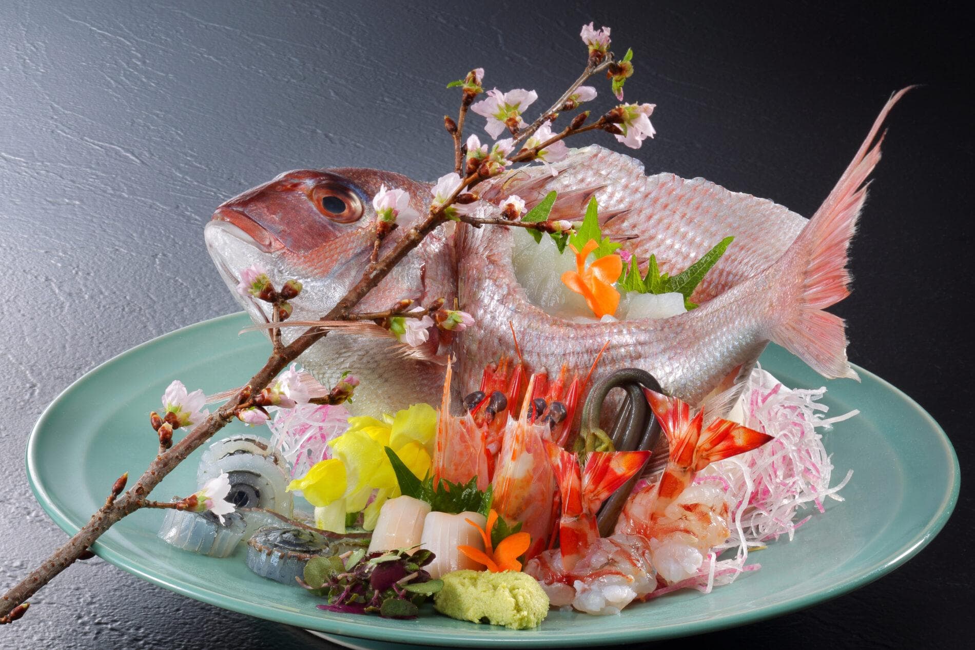 Whole sea bream sashimi platter garnished with cherry blossom branch at Kinugawa Grand Hotel Yume no Toki