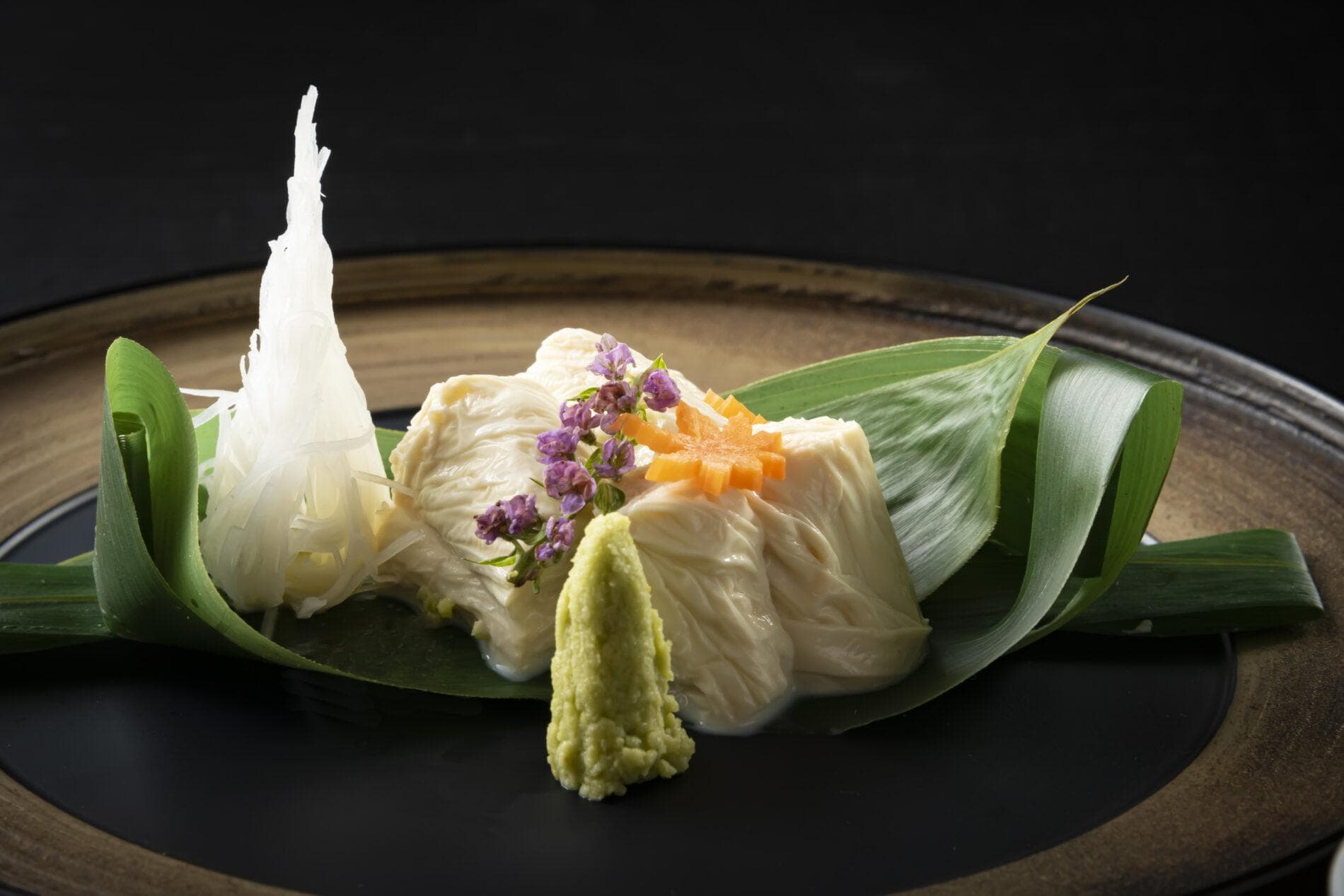 Plated yuba tofu appetizer garnished with wasabi and vegetables